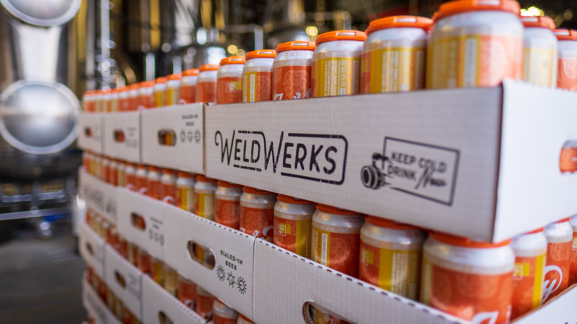 Canned WeldWerks beer six-packs in cardboard boxes with orange plastic holders