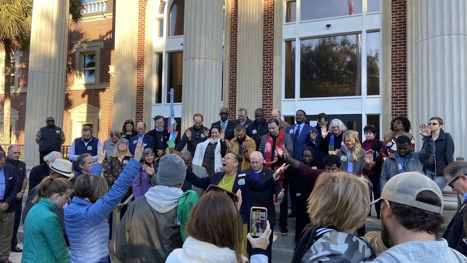 Group of people praying in front of Glynn County Courthouse