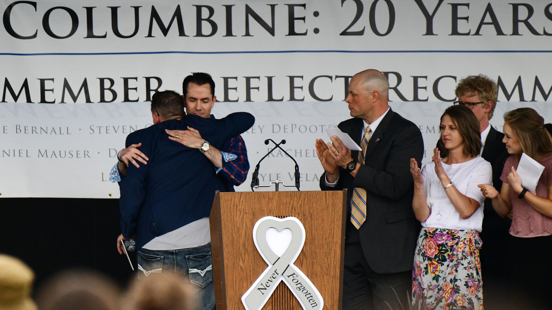  Columbine High School Shooting survivors Sean Graves, left, hugs Patrick Ireland during the Columbine: 20 memorial night.