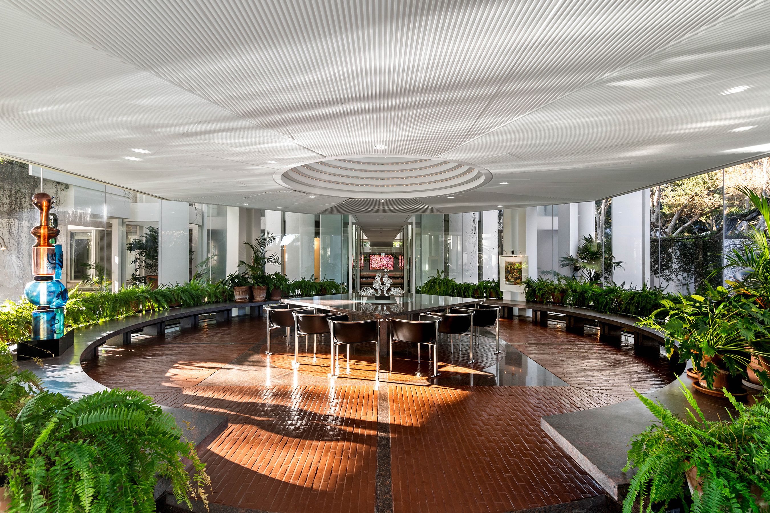 A photo of a round room surrounded by windows with a circular dining room table in the middle