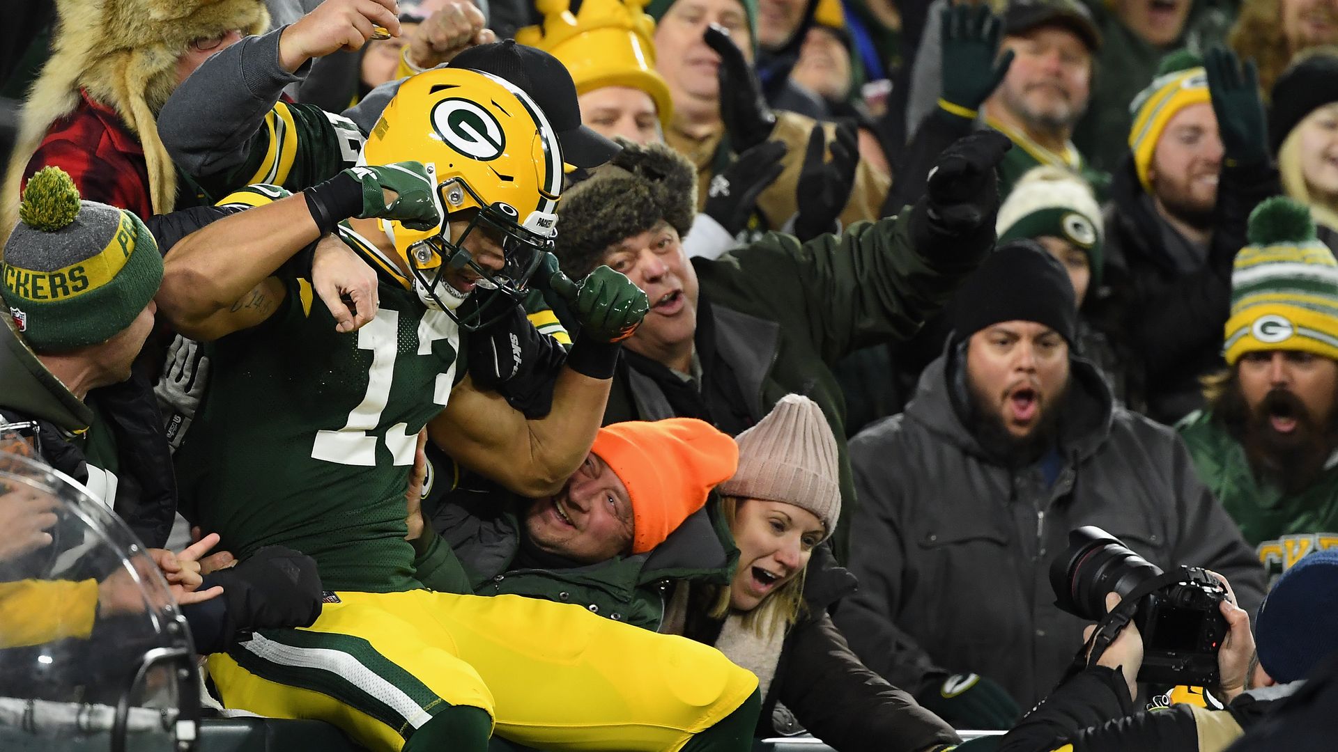 A photo of a football player jumping into the stands. 