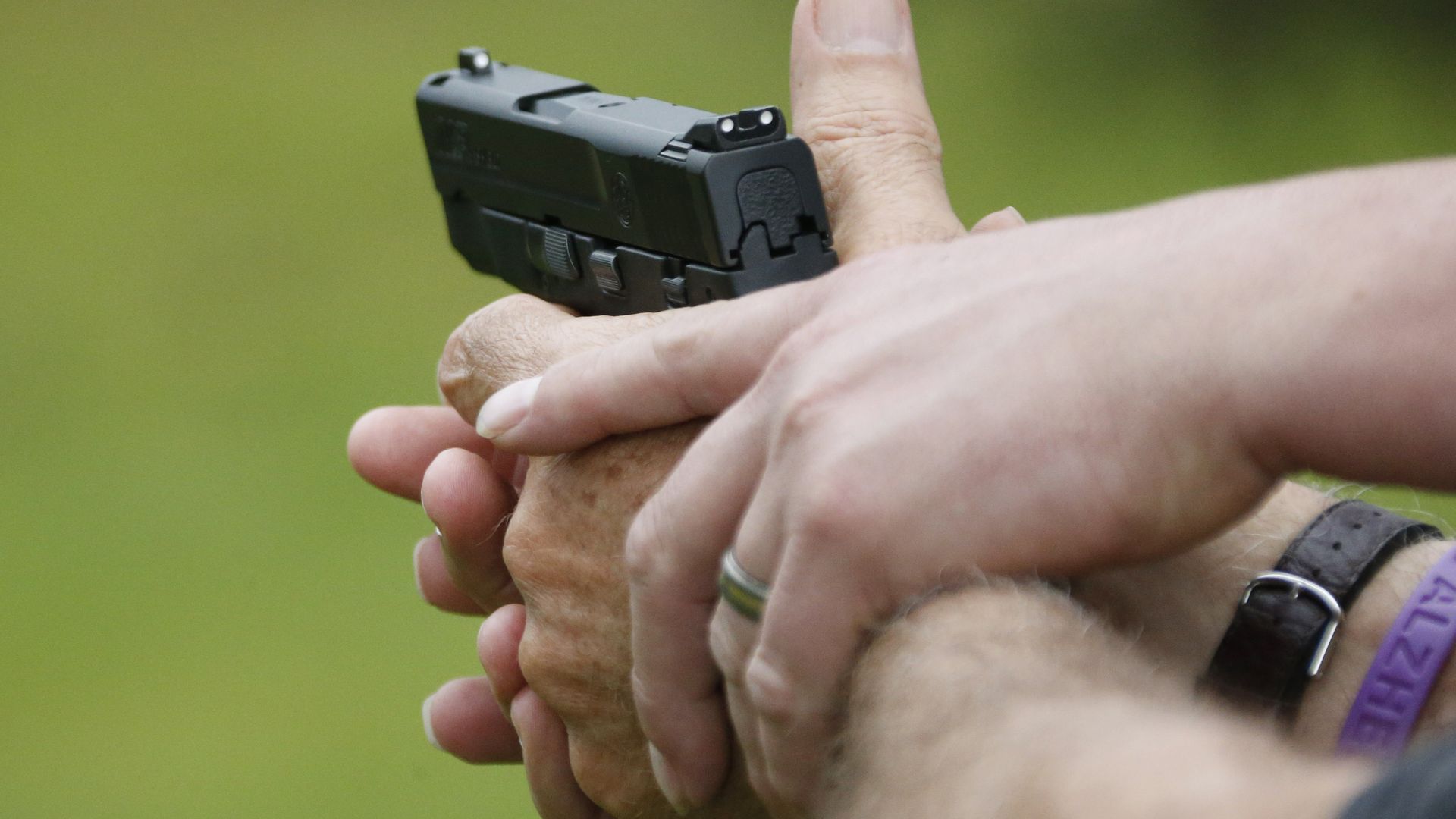 a Gun Guy Tactical instructor, helps a participant properly hold his firearm. 