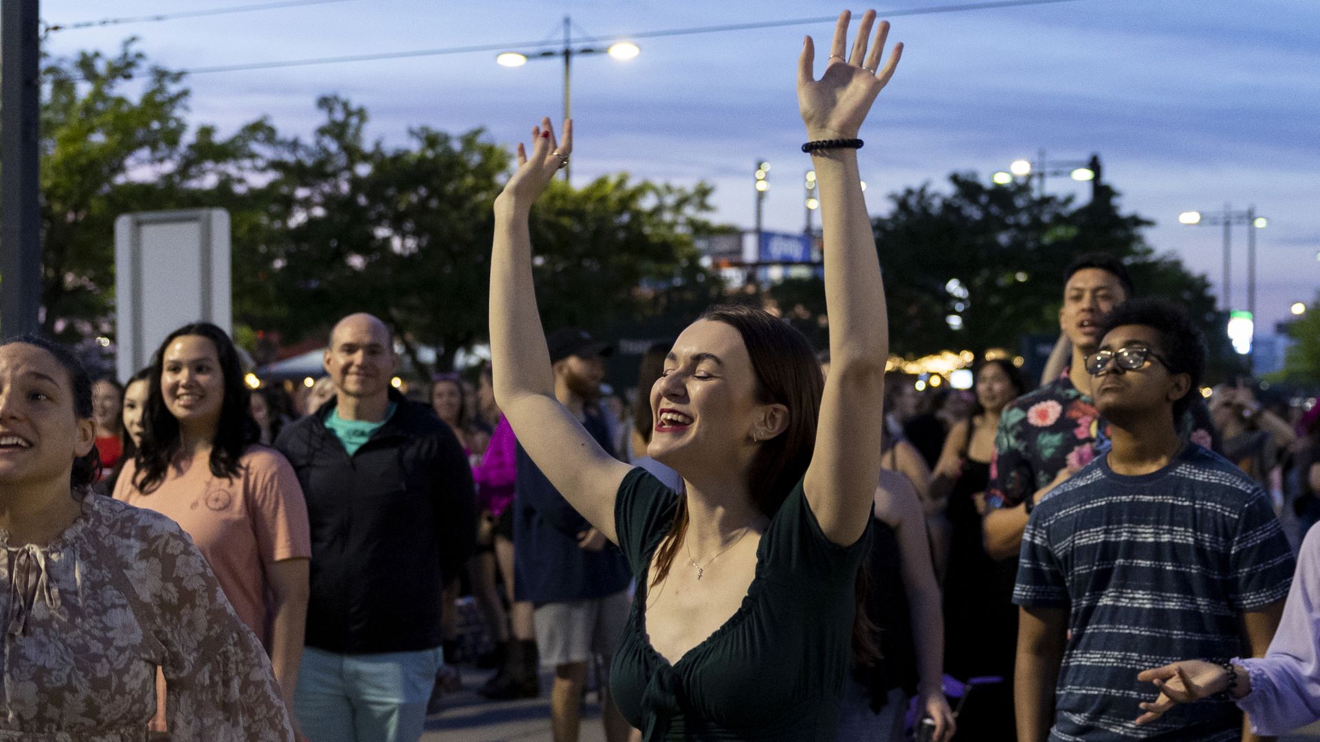 Natalie Williams (center) dances at the Taylor Swift concert, which she is listening to from the parking lot outside of Lincoln Financial Field, in Philadelphia, Pennsylvania on May 13, 2023. 