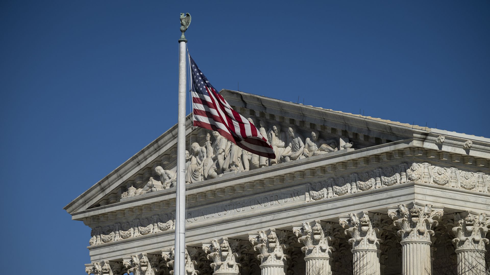 Image of the SCOTUS building with an American flag