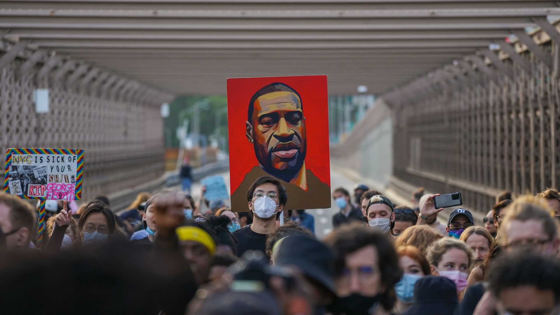Picture of protesters holding a painting of George Floyd