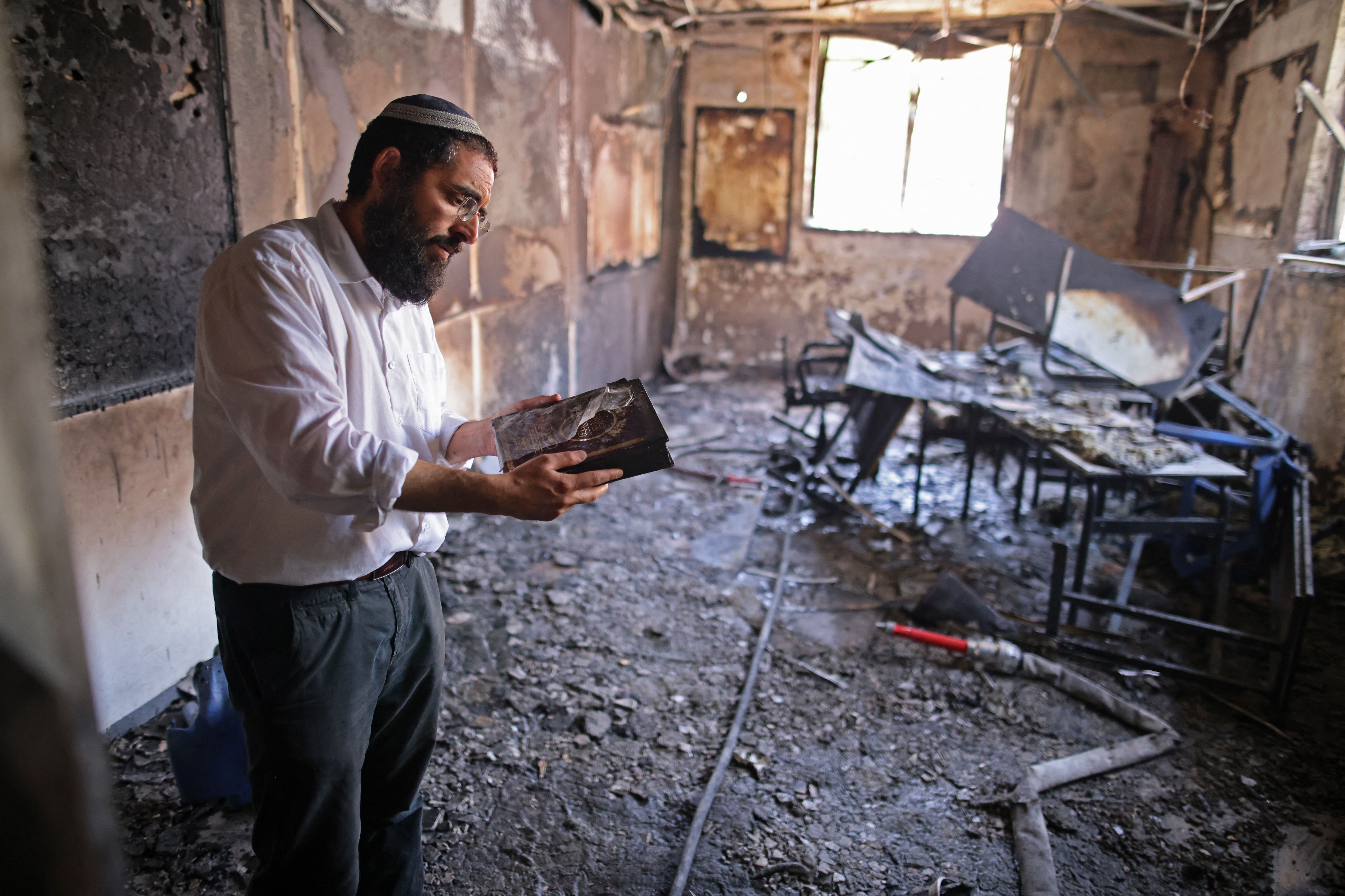 A Rabbi inspects the damage inside a torched religious school in the central Israeli city of Lod, near Tel Aviv, on May 11