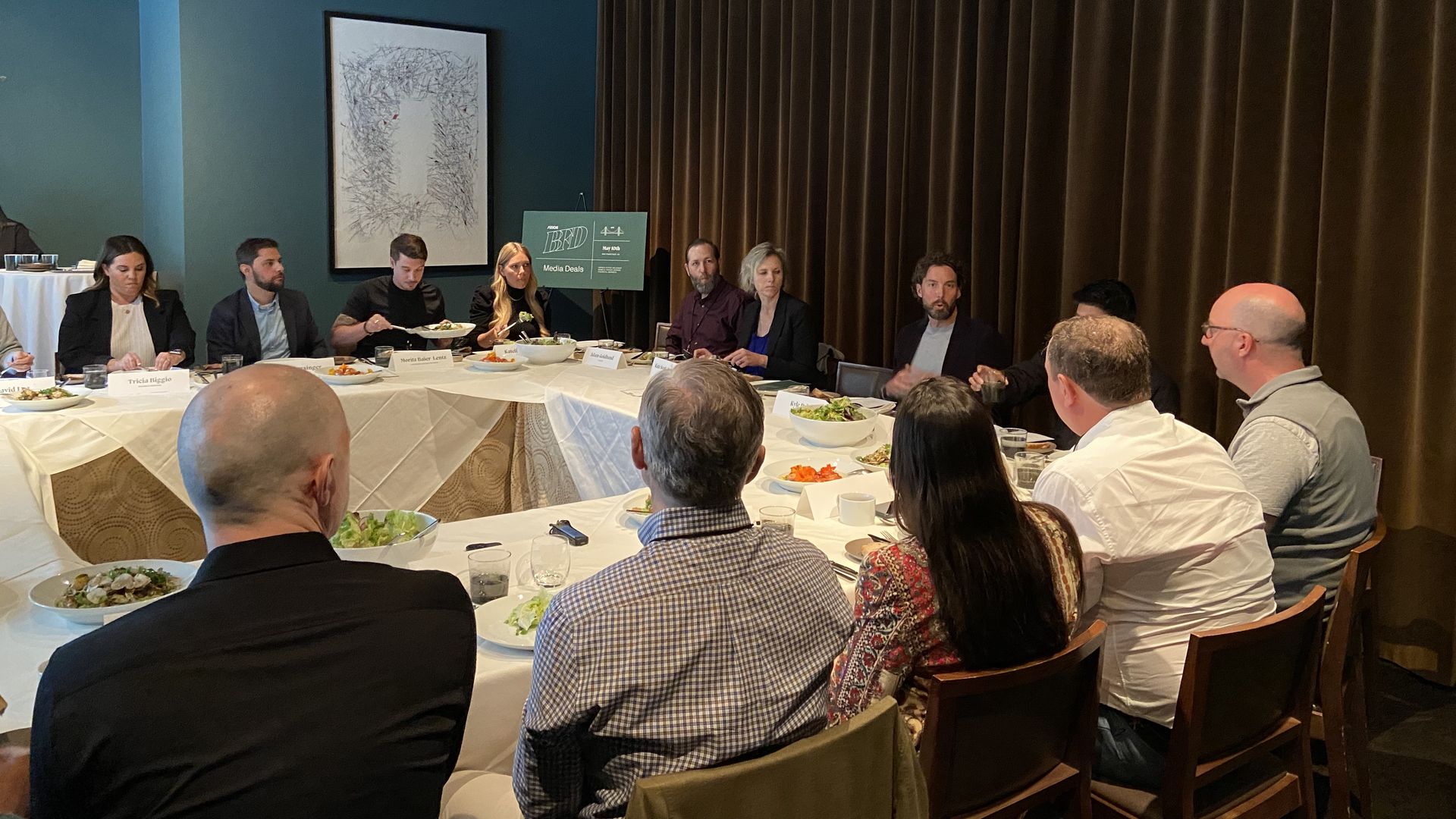 People talking while seated around a set of tables