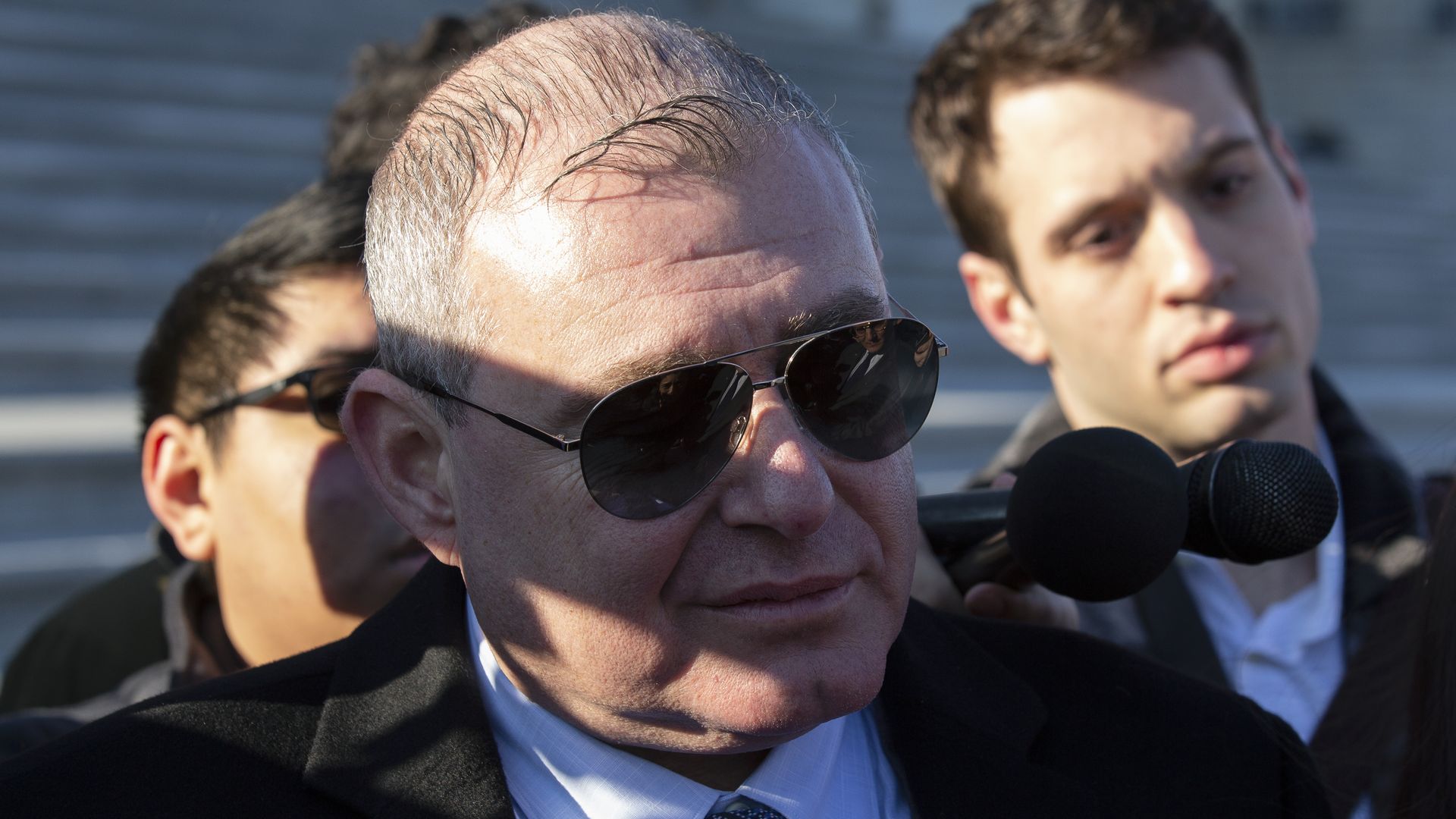 Photo of Lev Parnas wearing sunglasses and standing with two others