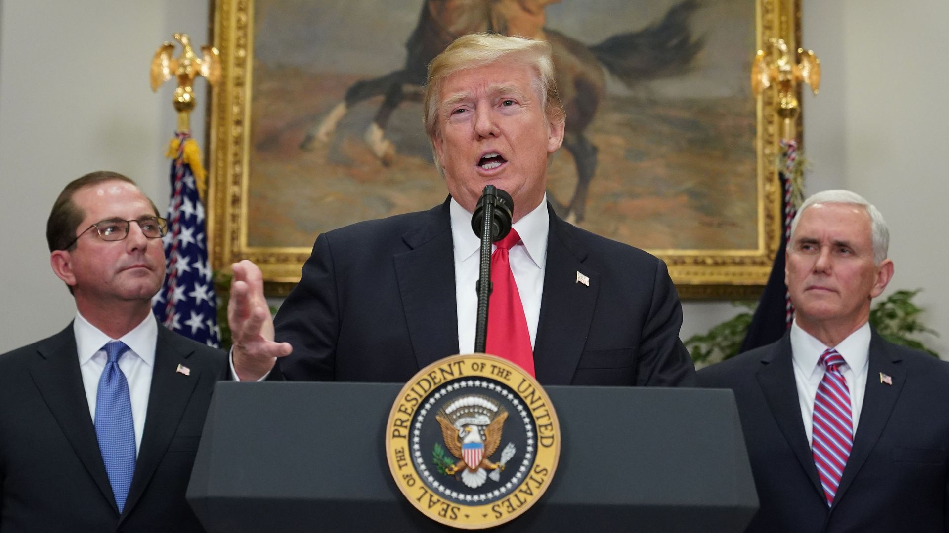 In this image, Trump speaks into a microphone at a podium in the White House, with a portrait of Teddy Roosevelt behind him.