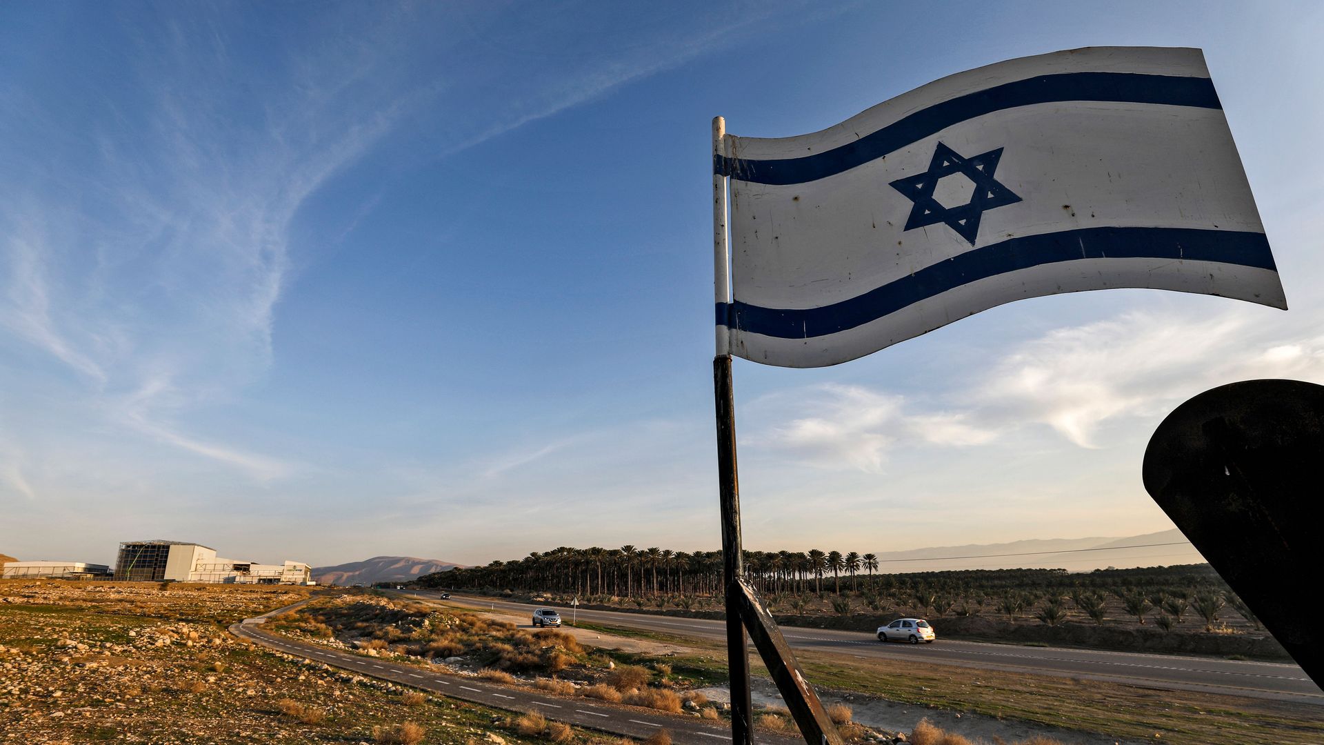 An Israeli flag flies by a roadside.