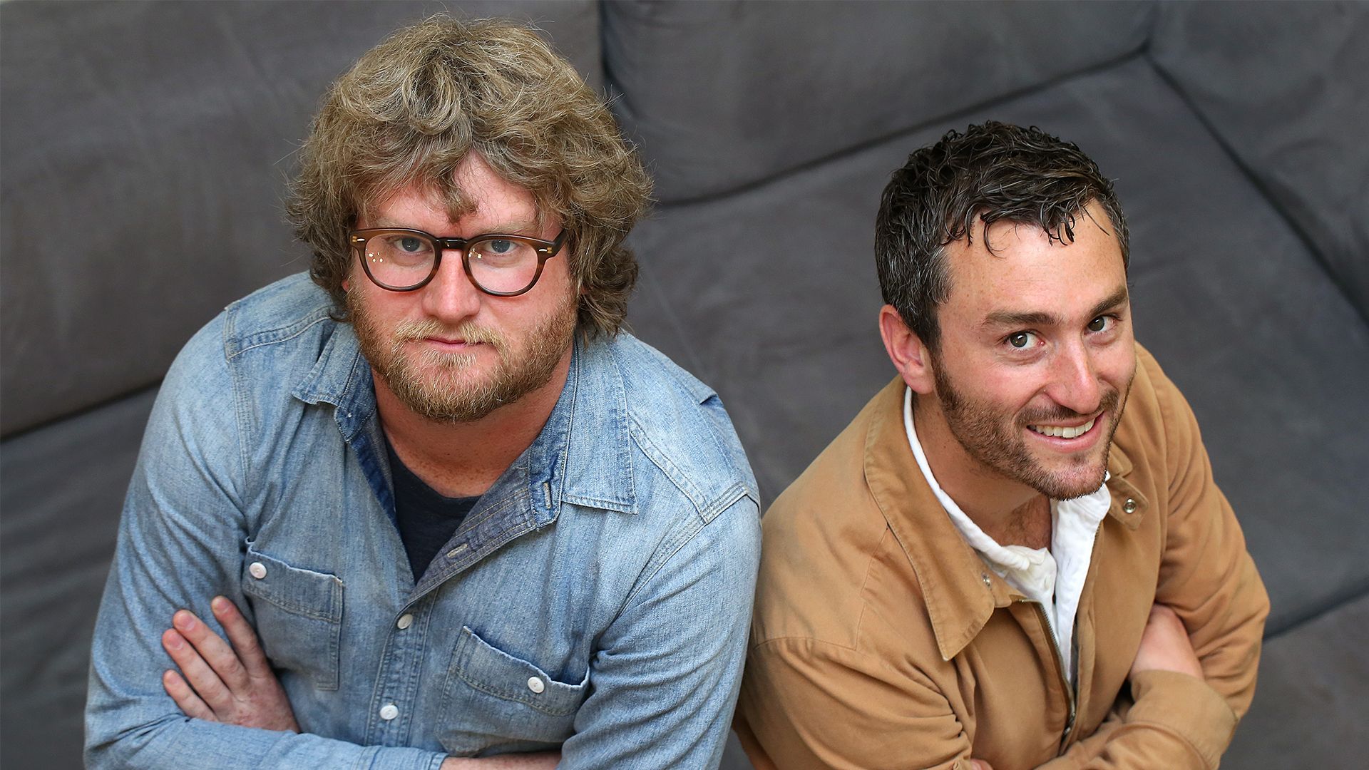 Two people with crossed arms standing next to each other.