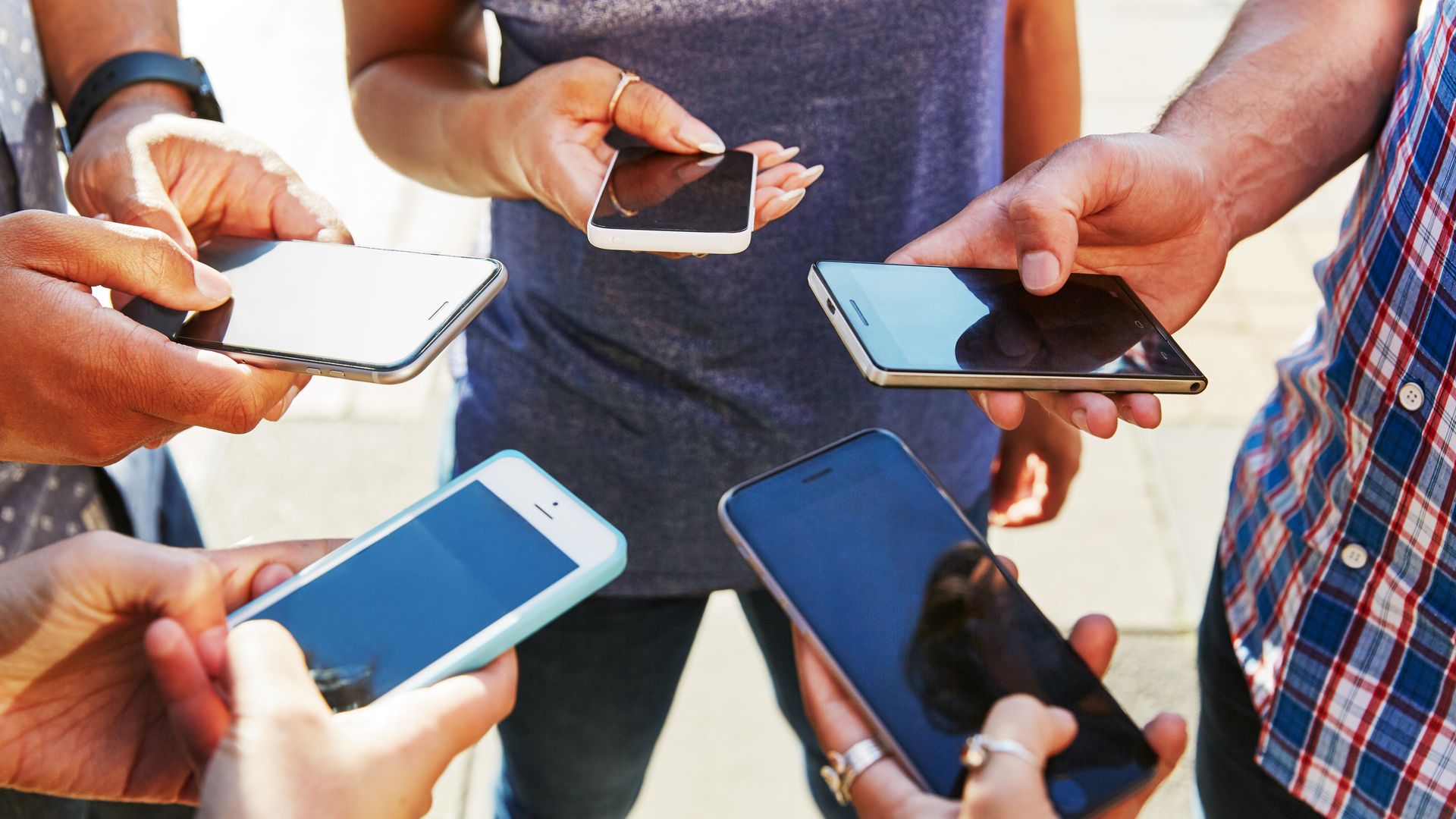 People in a group holding their cellphone