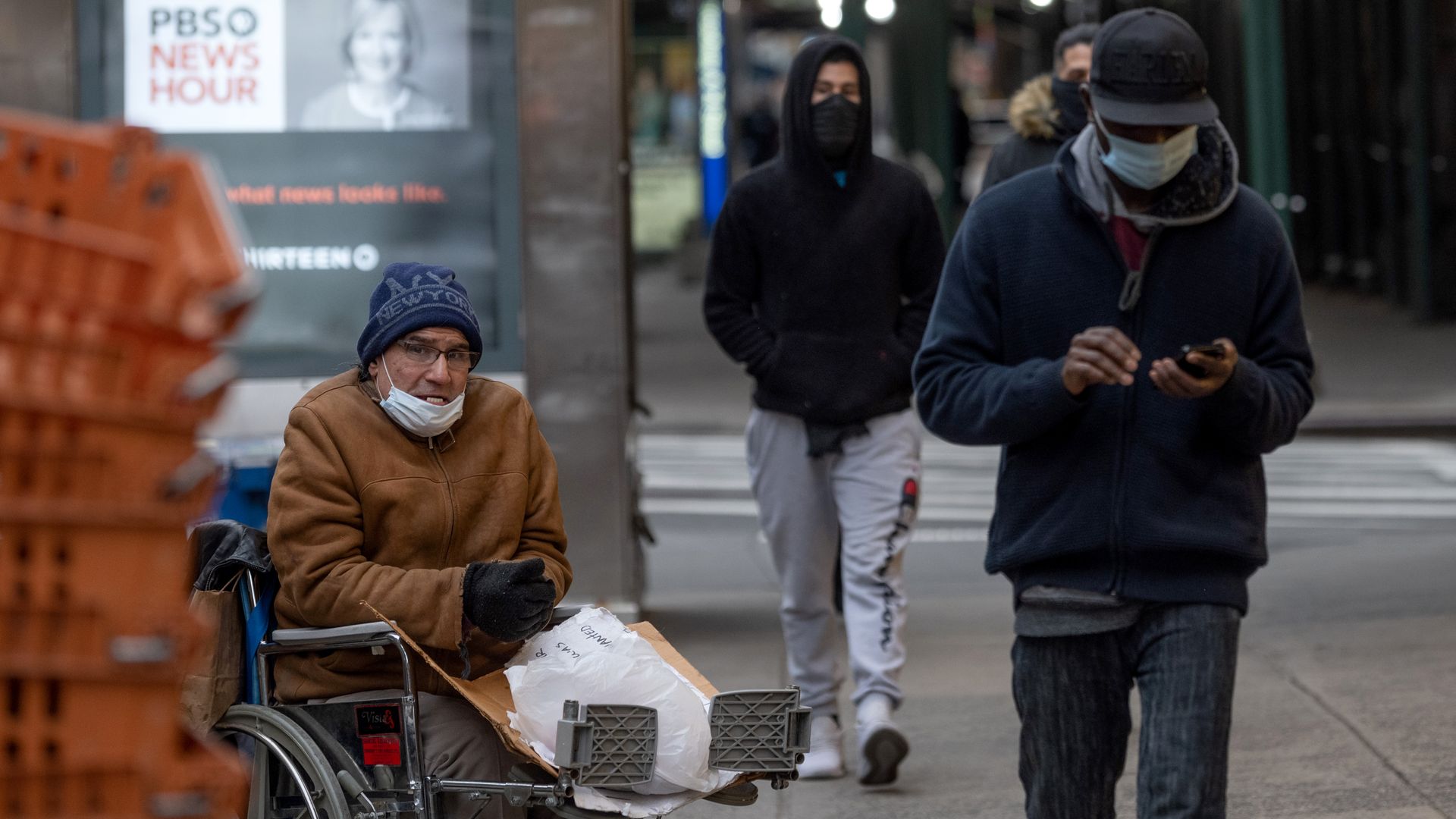 A photo of a man in a wheelchair wearing a mask.