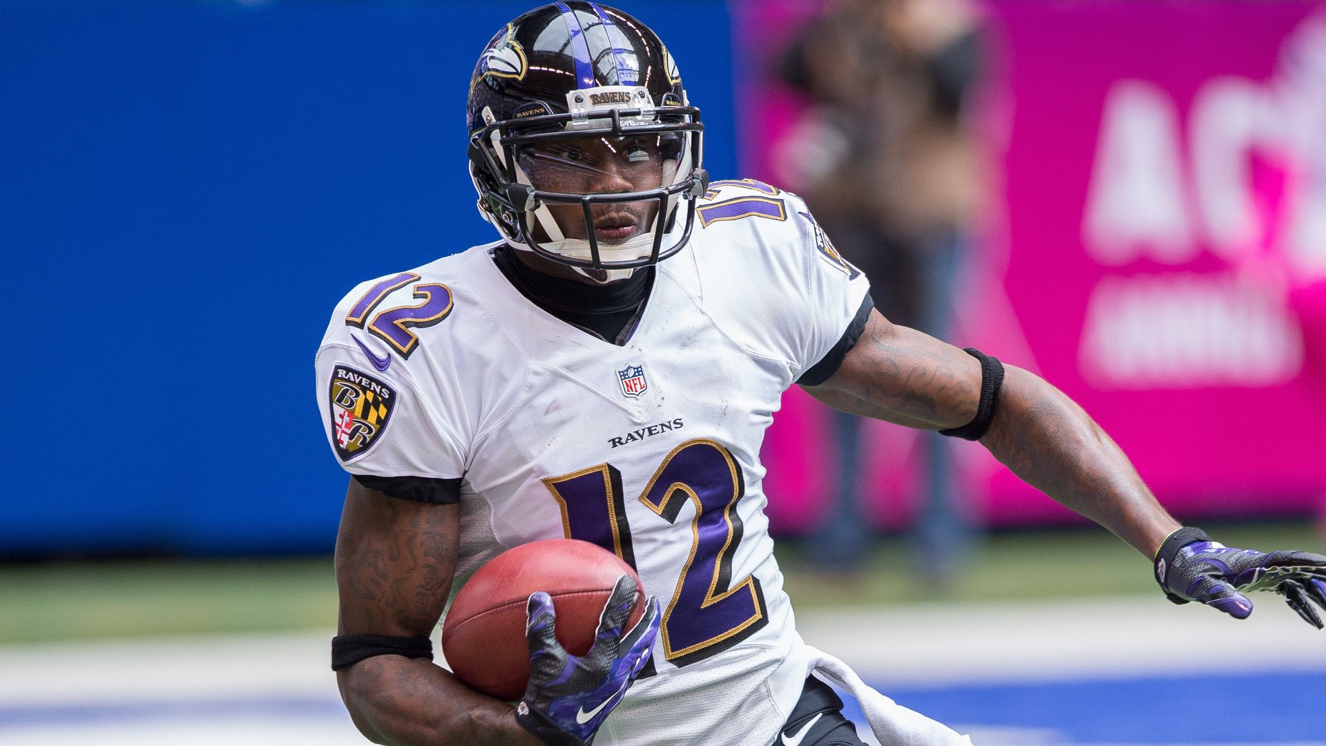 Photo shows Jacoby Jones in a Baltimore Ravens jersey holding a football.