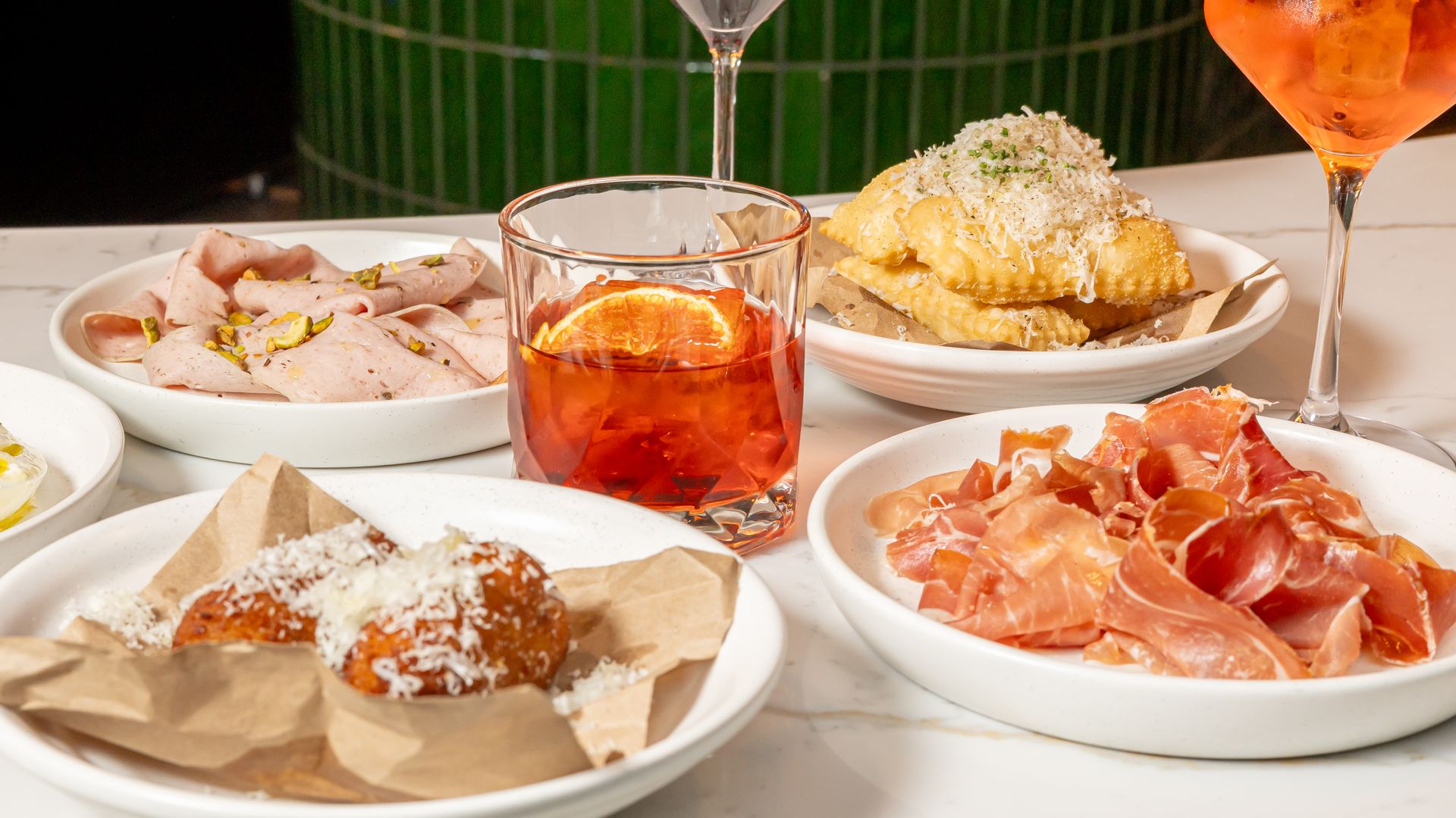 A marble bar with Italian plates like prosciutto and spritzes