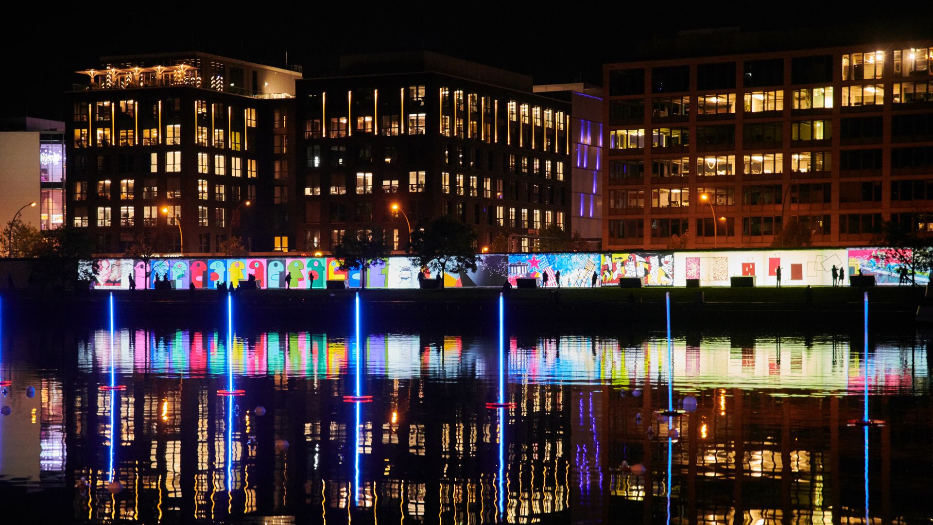 video projection onto Berlin wall with glow reflected in the Spree river