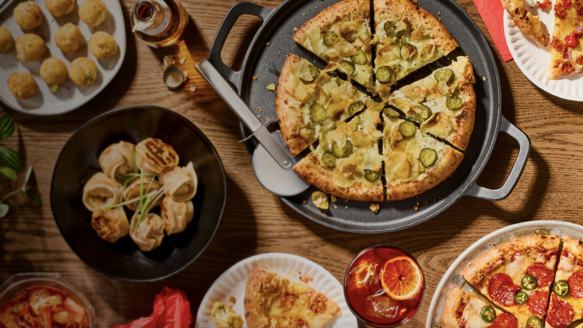 a table with pickle pizza, pepperoni pizza and dumplings