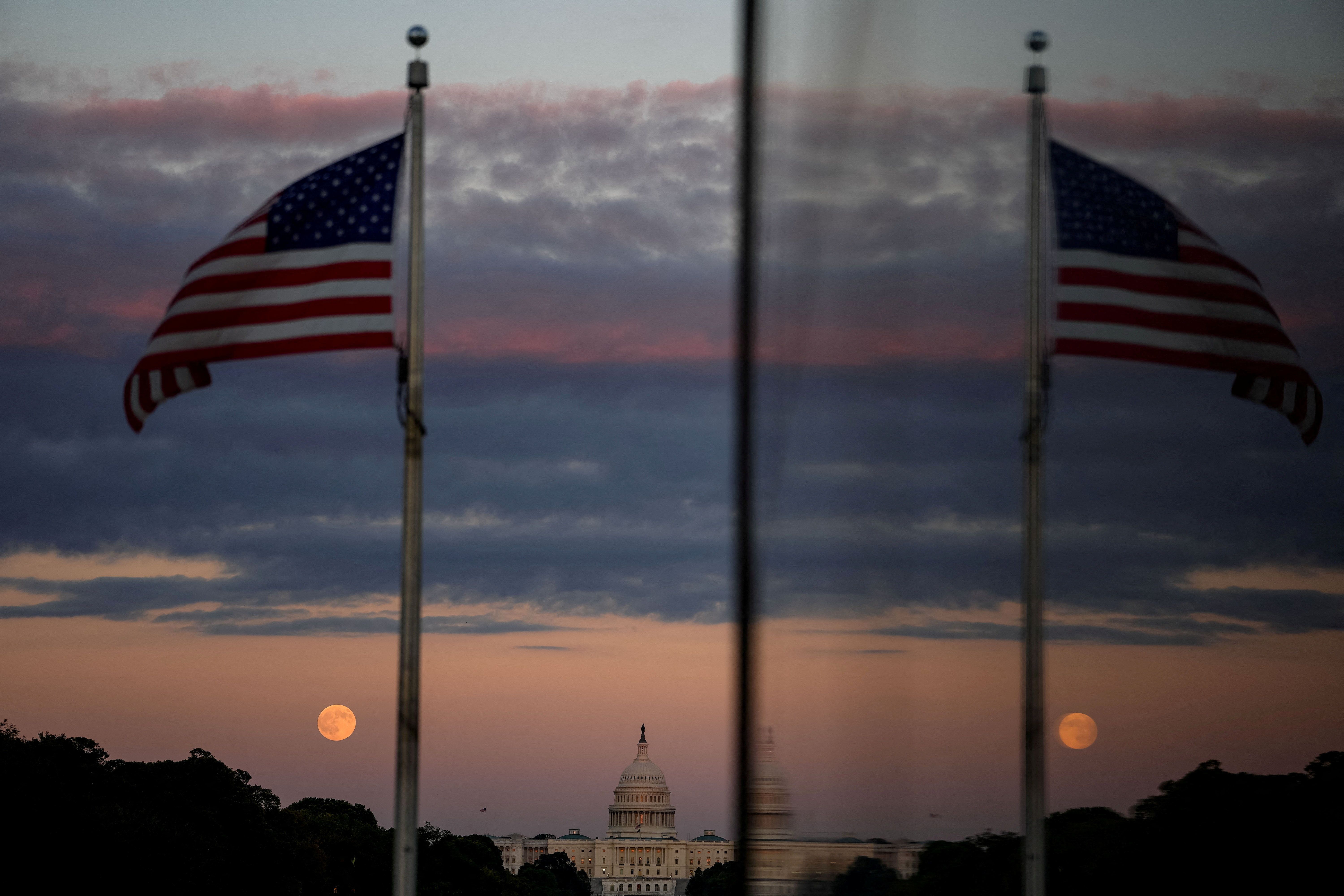 The first supermoon of the year, known as the Harvest Moon, rises above the National Mall, in view of the dome of the U.S. Capitol from the Washington Monument.