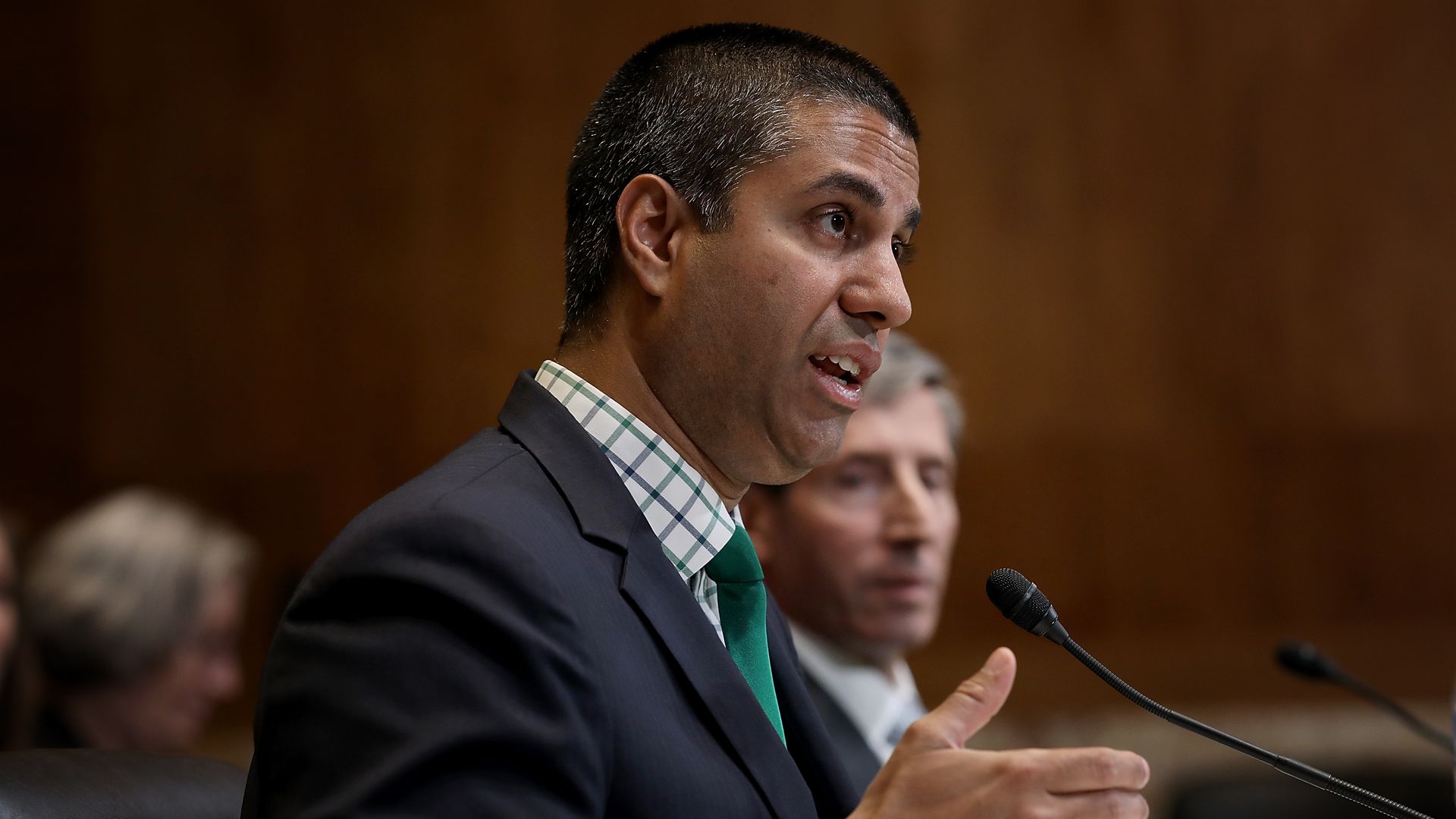 FCC Chairman Ajit Pai speaks into a microphone at a congressional hearing