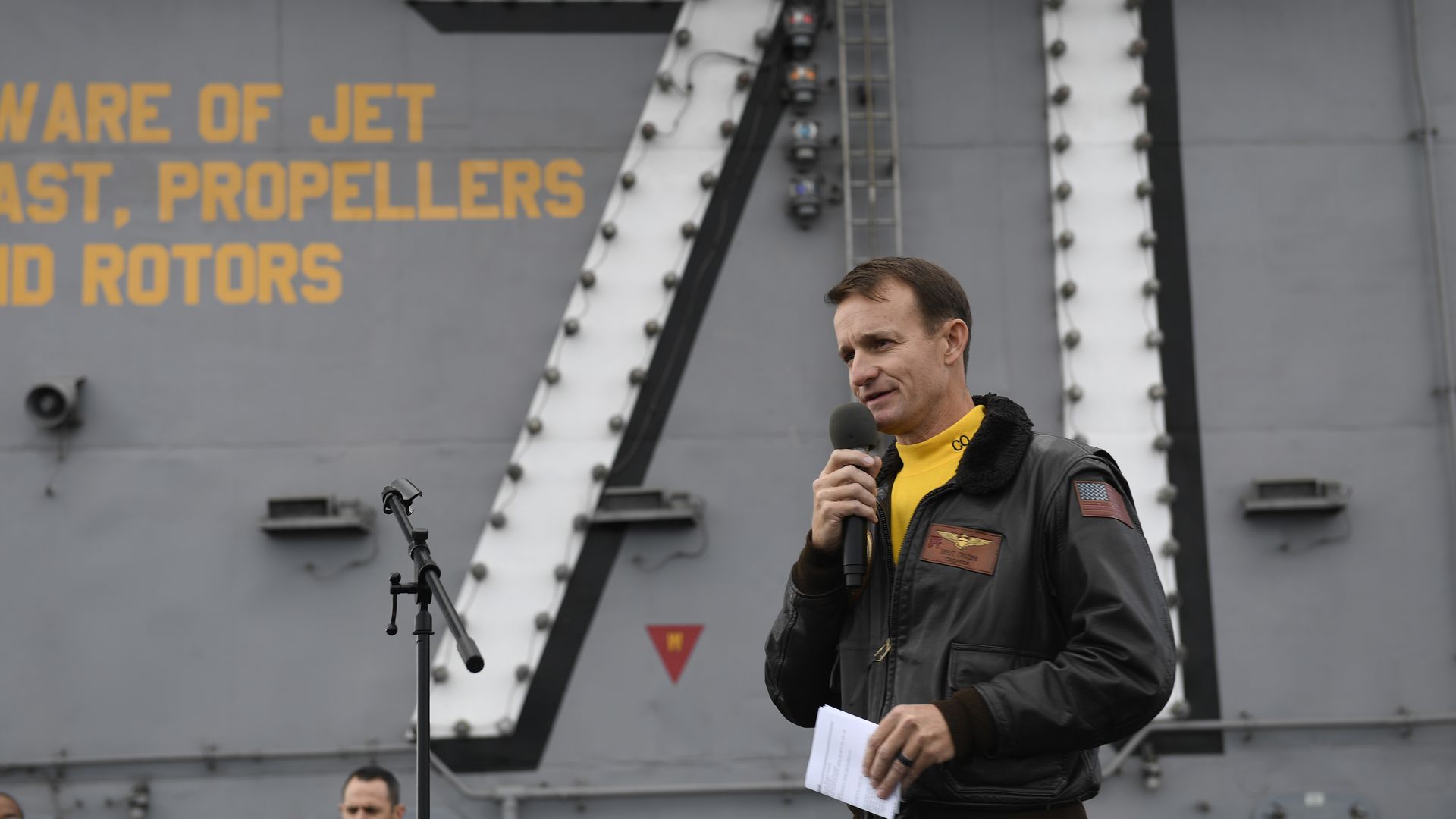 Brett Crozier holds a microphone 