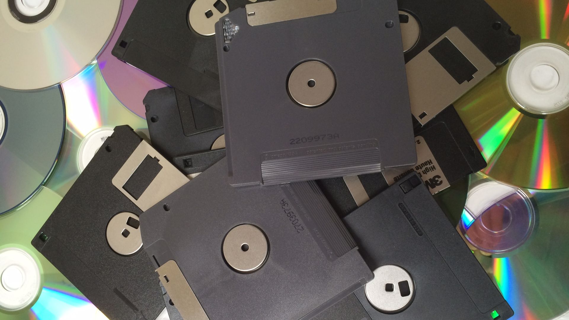 This image is a pile of floppy disks and CD-roms.