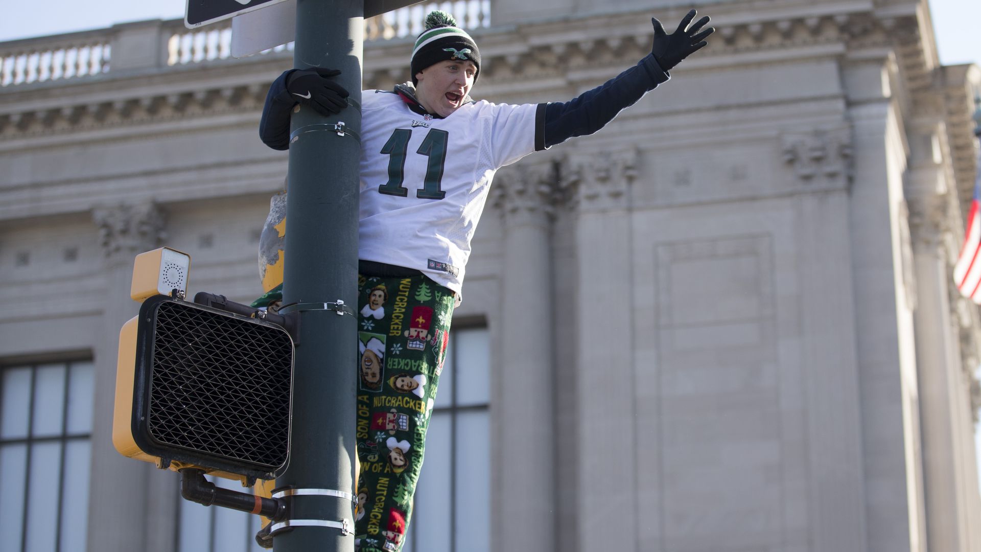 A man climbing on a street pole.