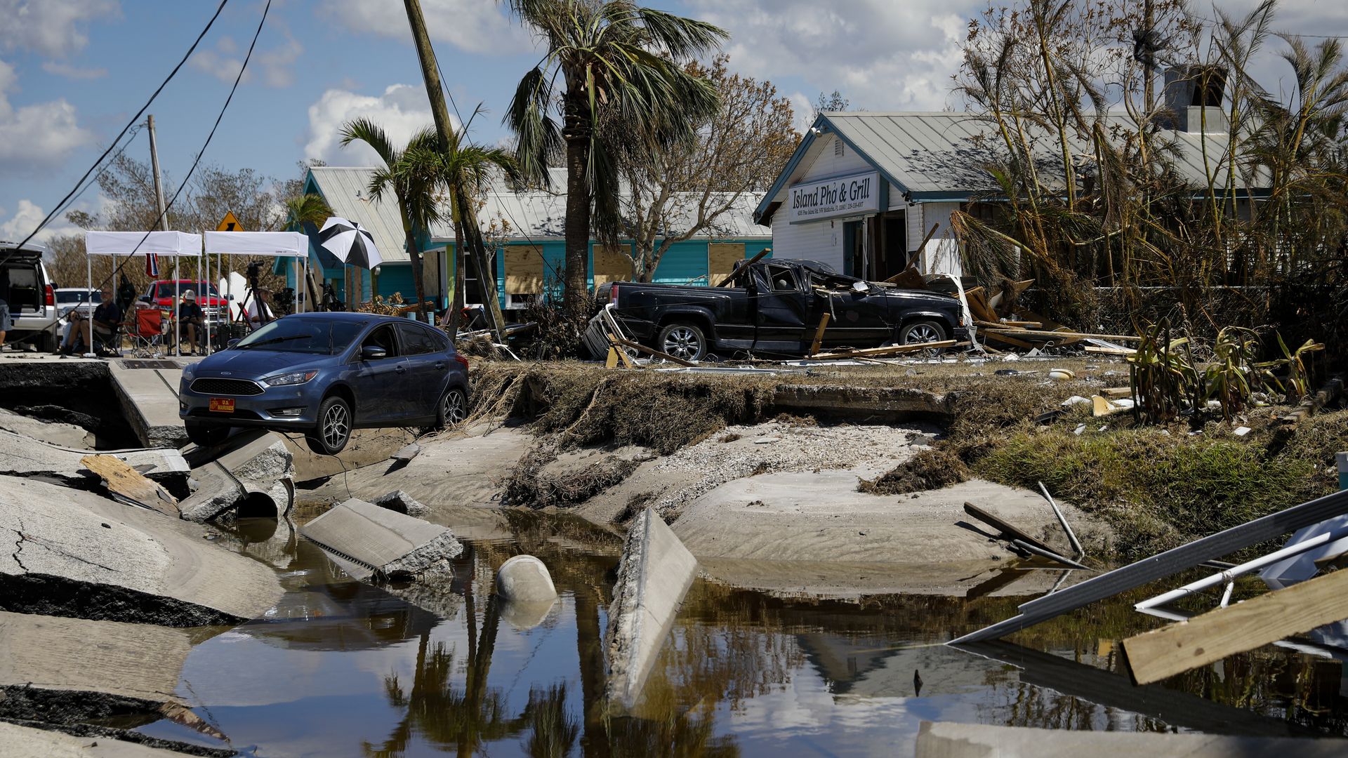 A vehicle sits on the destroyed Pine Island Road following Hurricane Ian