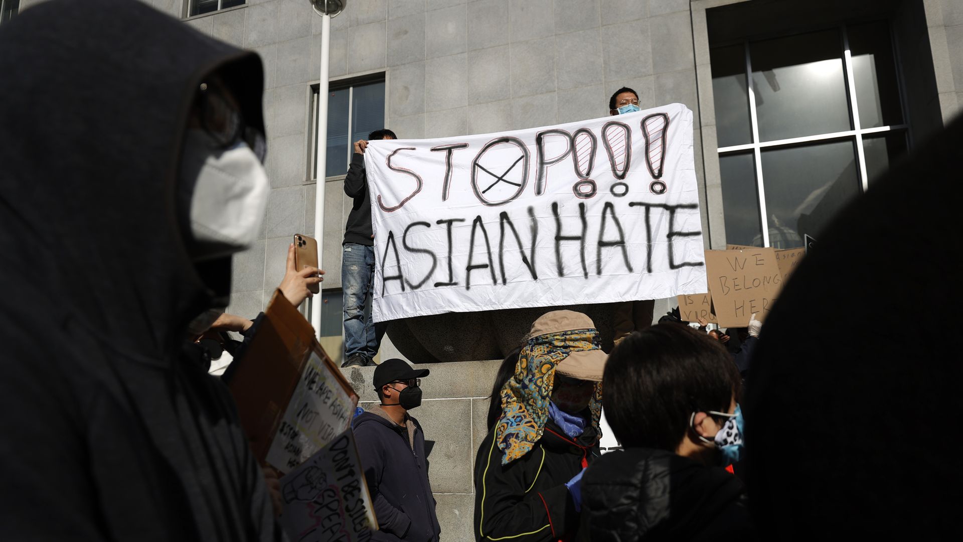 Photo of protesters holding a sign that says 'Stop Asian Hate" during a rally in solidarity with Asian hate crime victims outside of the San Francisco Hall of Justice