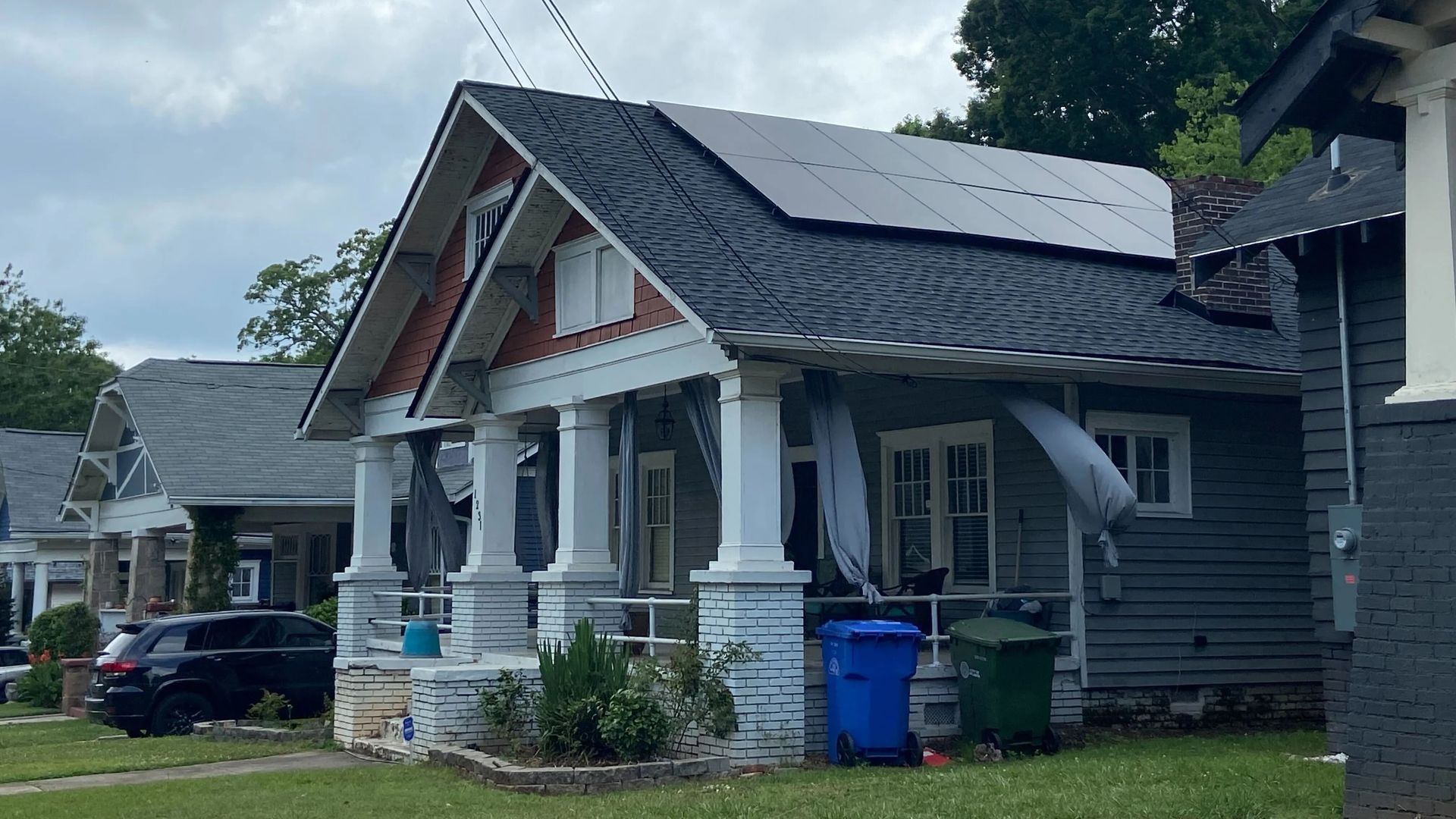 A historic house in Atlanta with a large solar panel on the sloped roof.