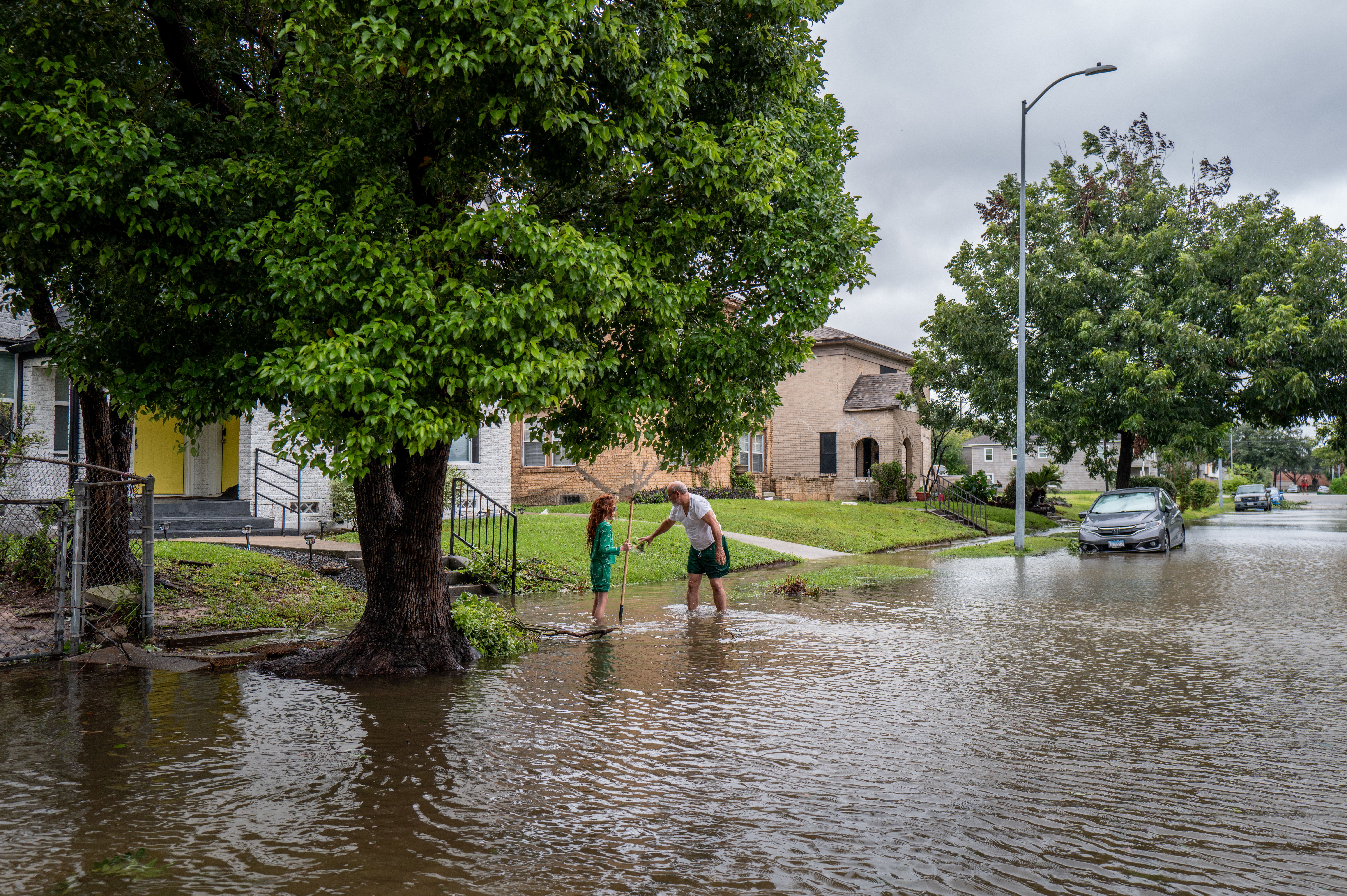 work to drain floodwater in their neighborhood after Hurricane Beryl swept through the area on July 08, 2024 in Houston, Texas
