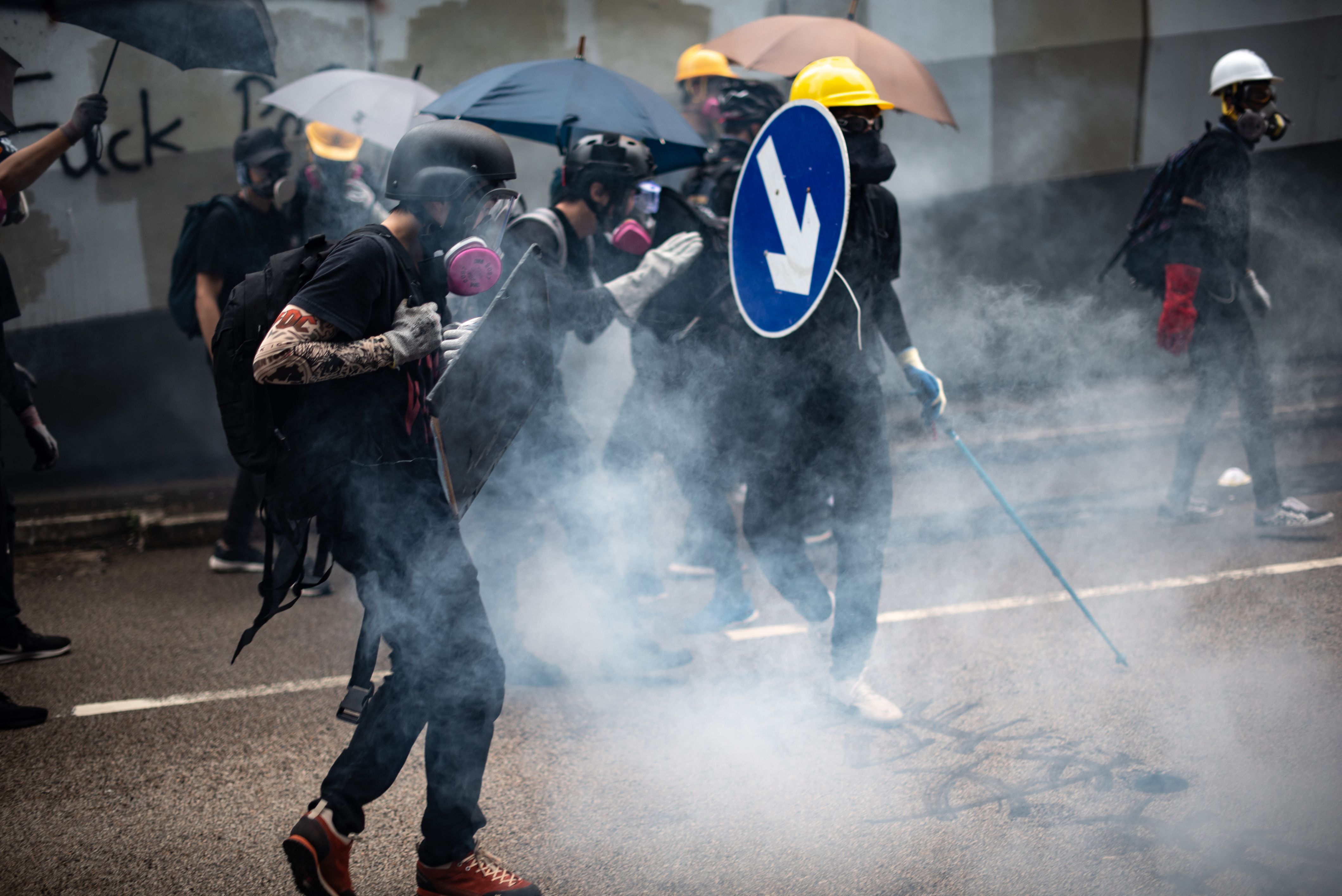 Protesters react after police fired tear gas outside the government headquarters in Hong Kong