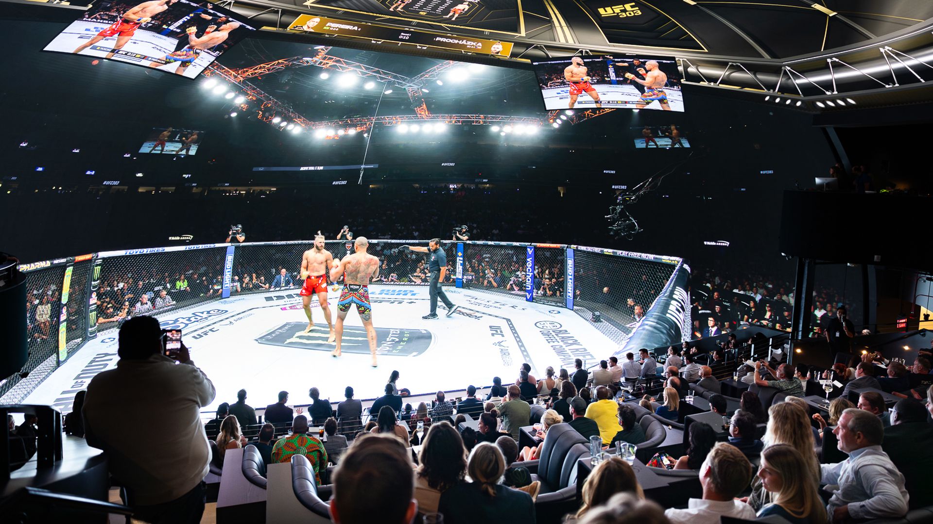 A crowd watches an 87-foot diameter high-resolution video dome broadcasting a mixed martial arts match