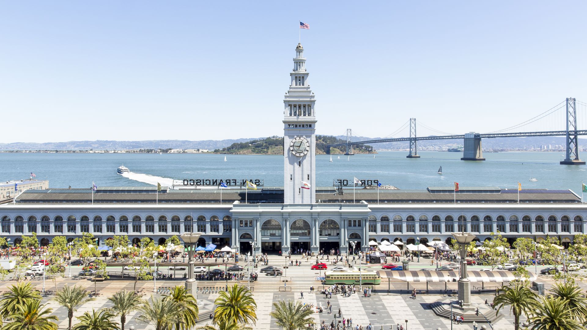 Aerial view of the Ferry Building with its looming clocktower and the bay in the background