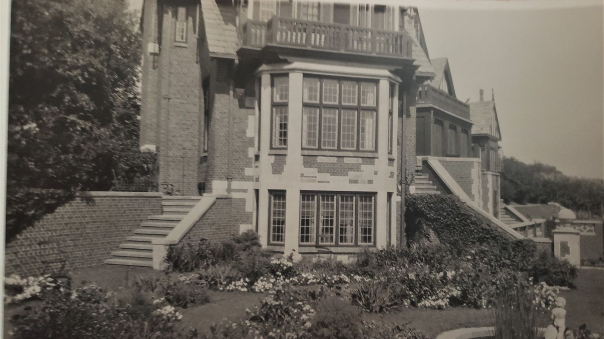 The back of Rollins Mansion featuring a garden