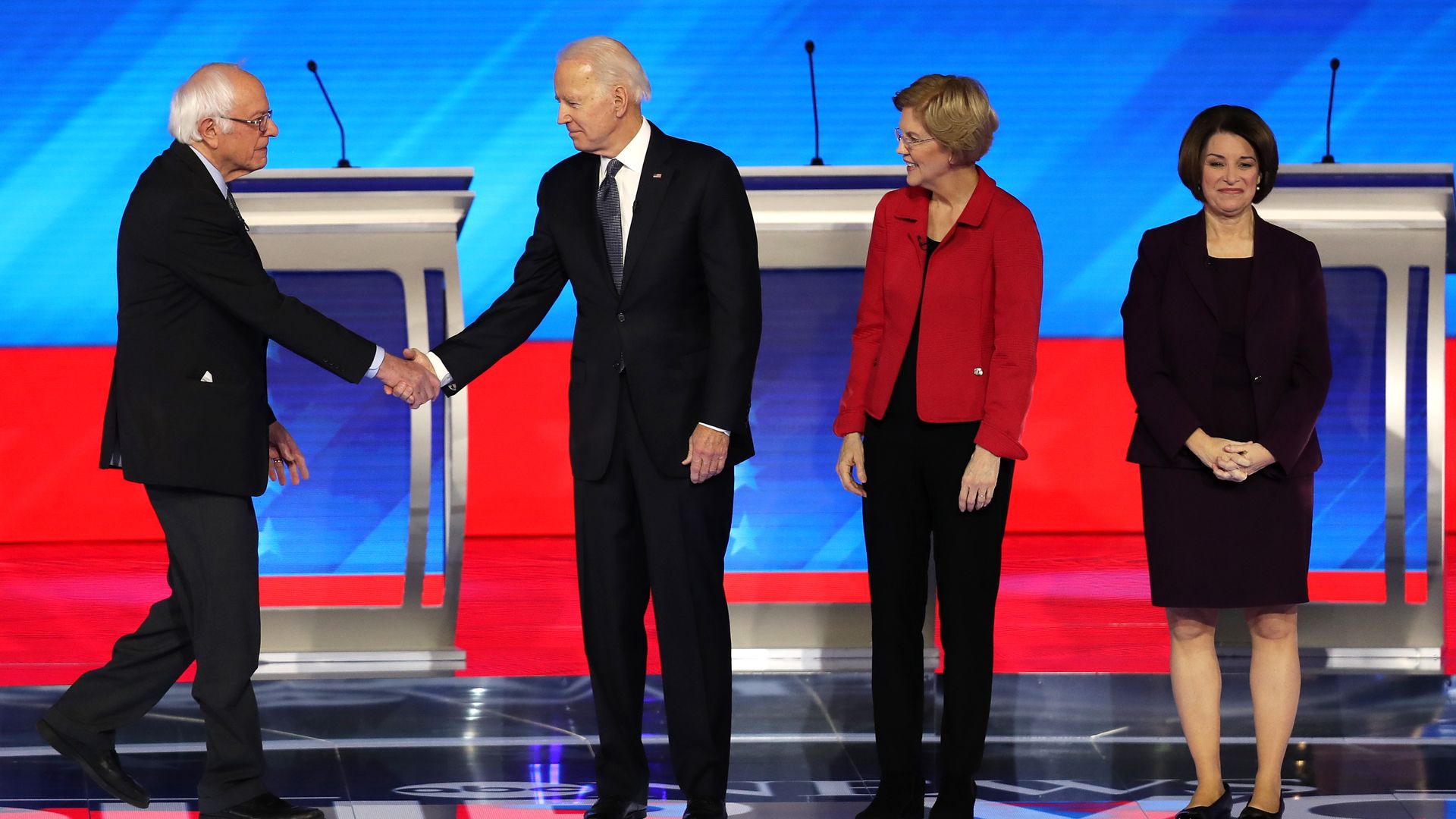 Sen. Bernie Sanders and former Vice President Joe Biden shake hands as the take the debate stage in NH
