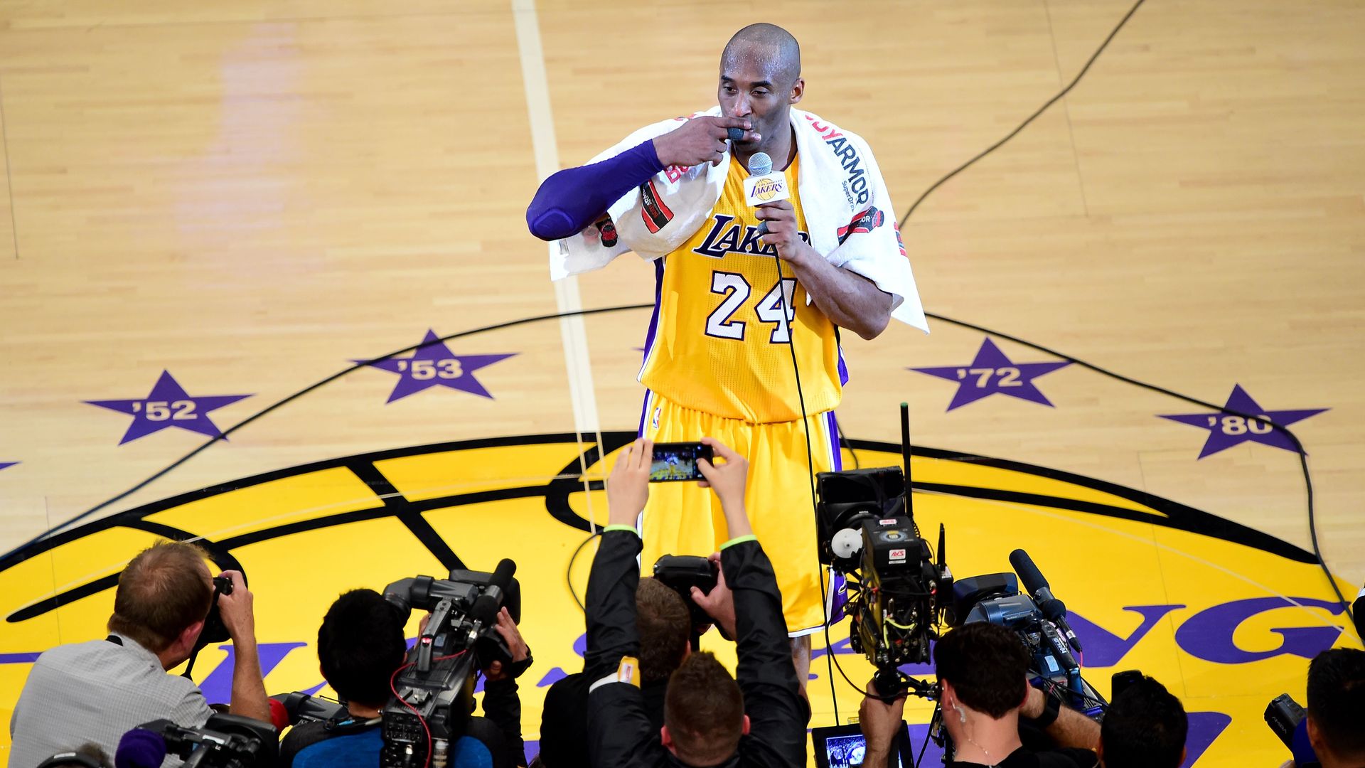 Kobe Bryant (top) of the Los Angeles Lakers reacts while addressing fans following his final game as a Laker in their season-ending NBA western division matchup aginst the Utah Jazz in Los Angeles