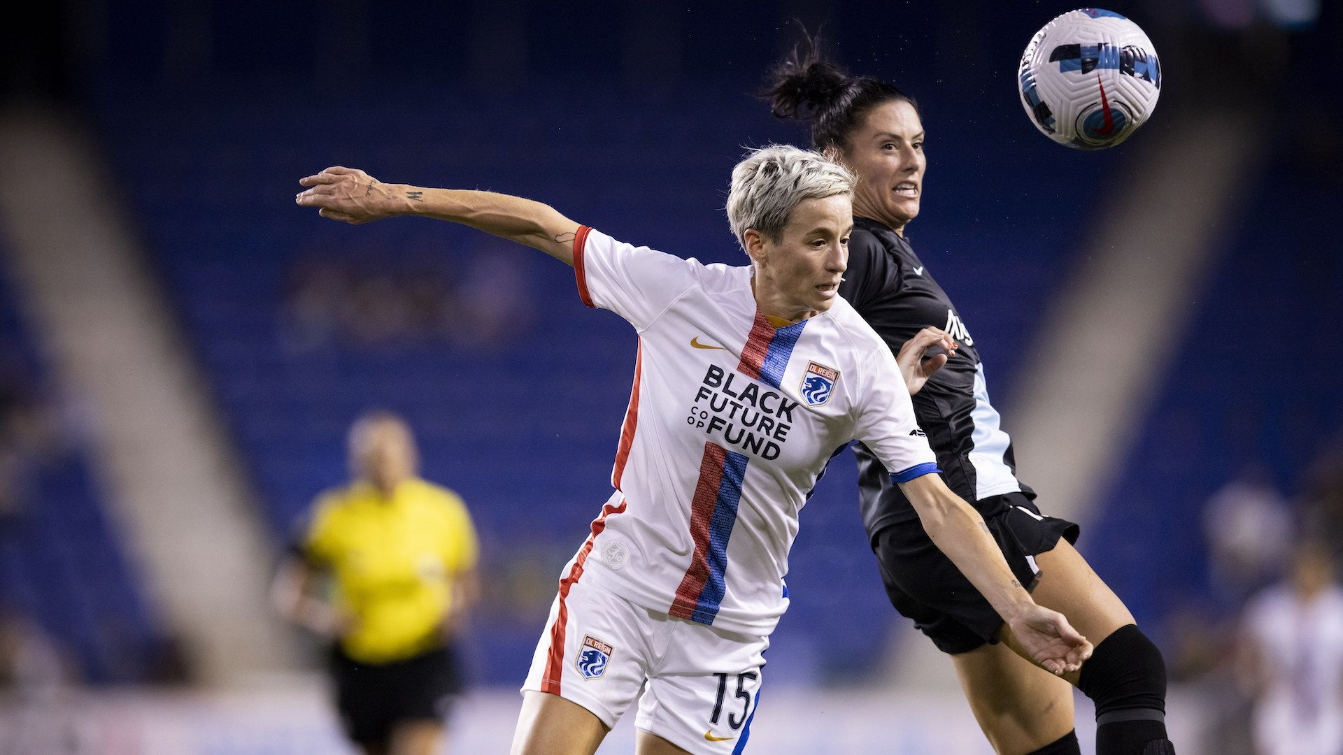 Two women's soccer players fight for a ball in the air.