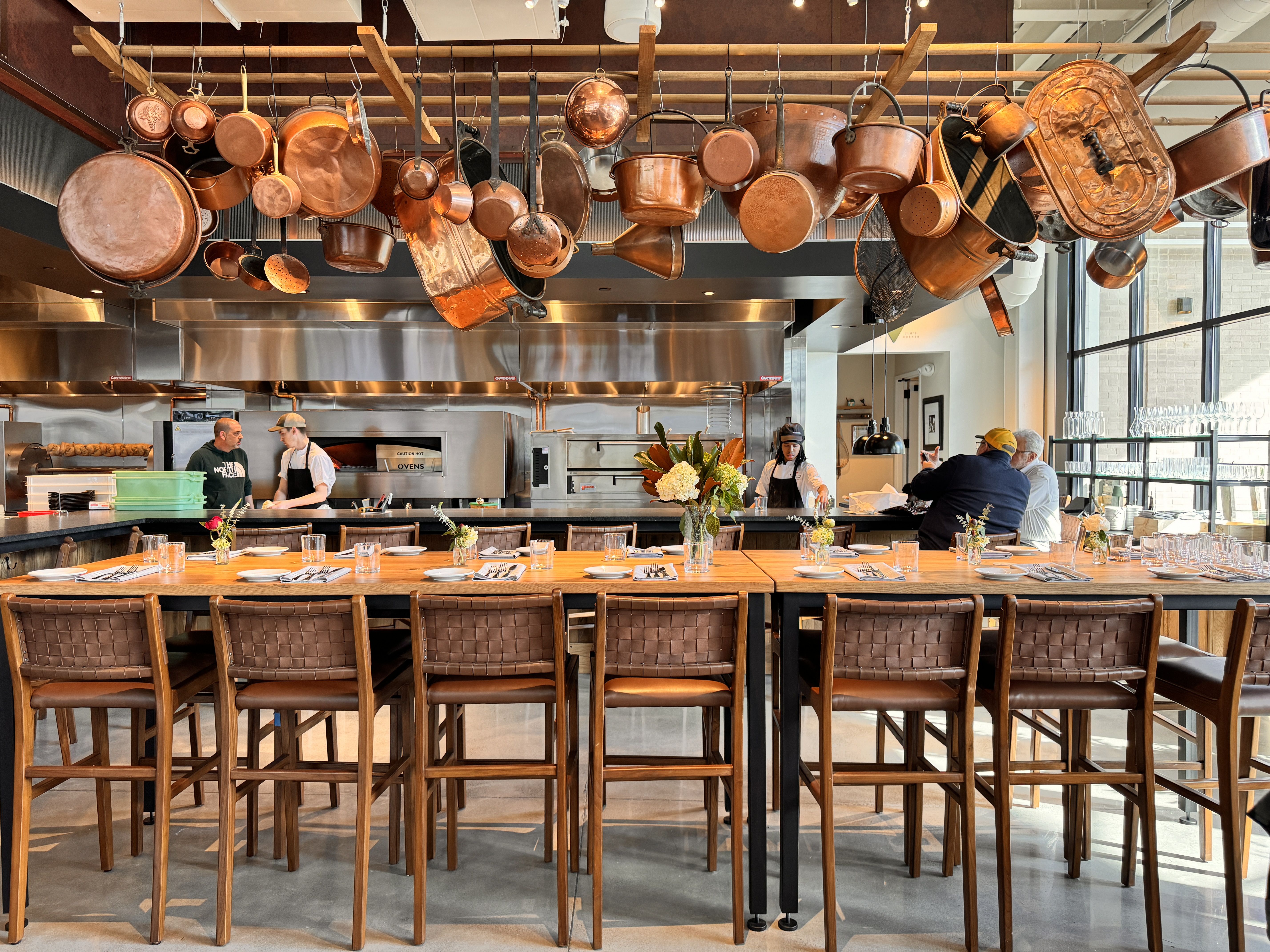 table with copper pots and pans hanging over it