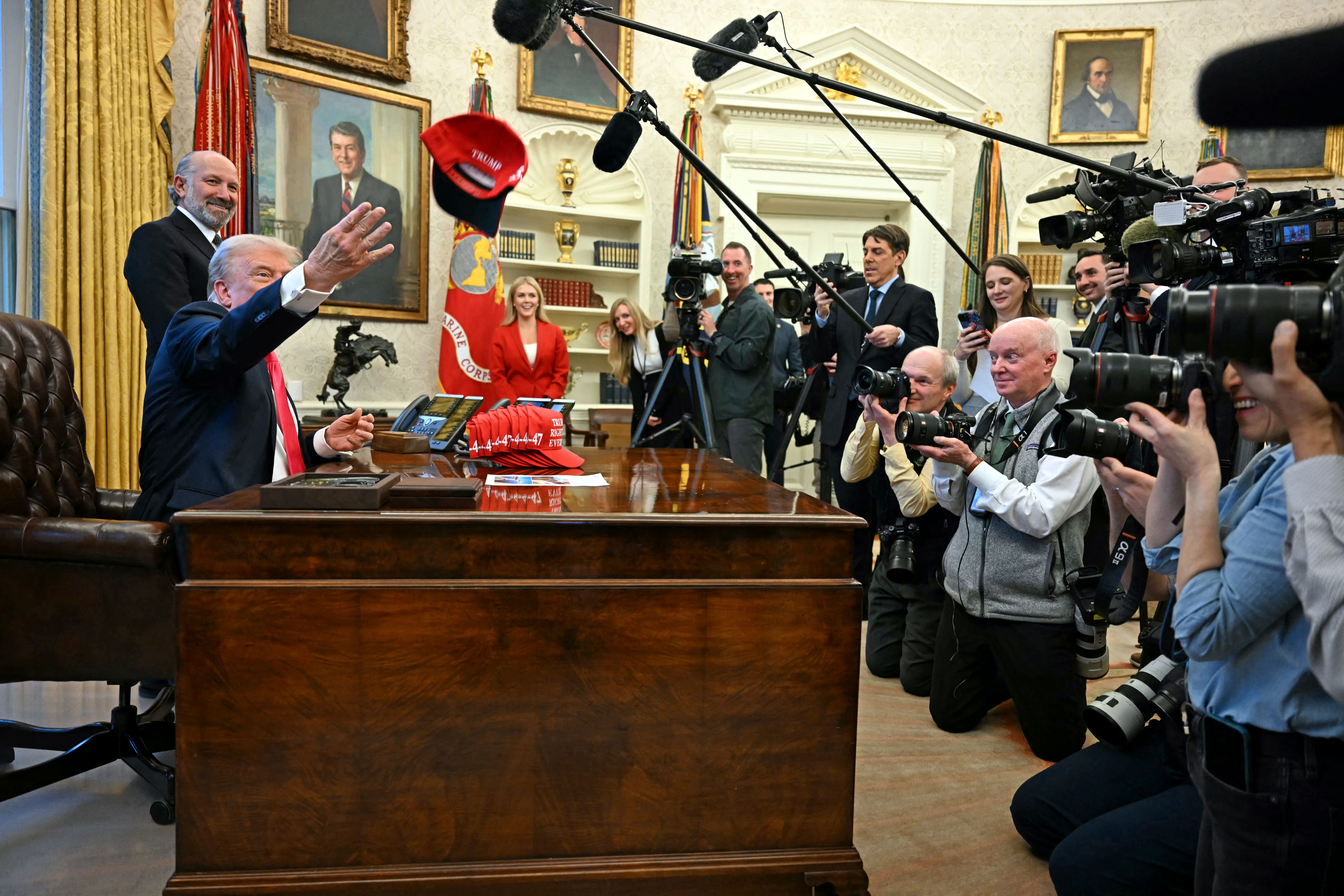 TOPSHOT - US President Donald Trump throws a hat reading "Trump was right about everything" after signing an Executive Order at the Oval Office of the White House in Washington, DC on February 25, 2025. Trump signed an executive order on price transparency requirements on the health care industry to