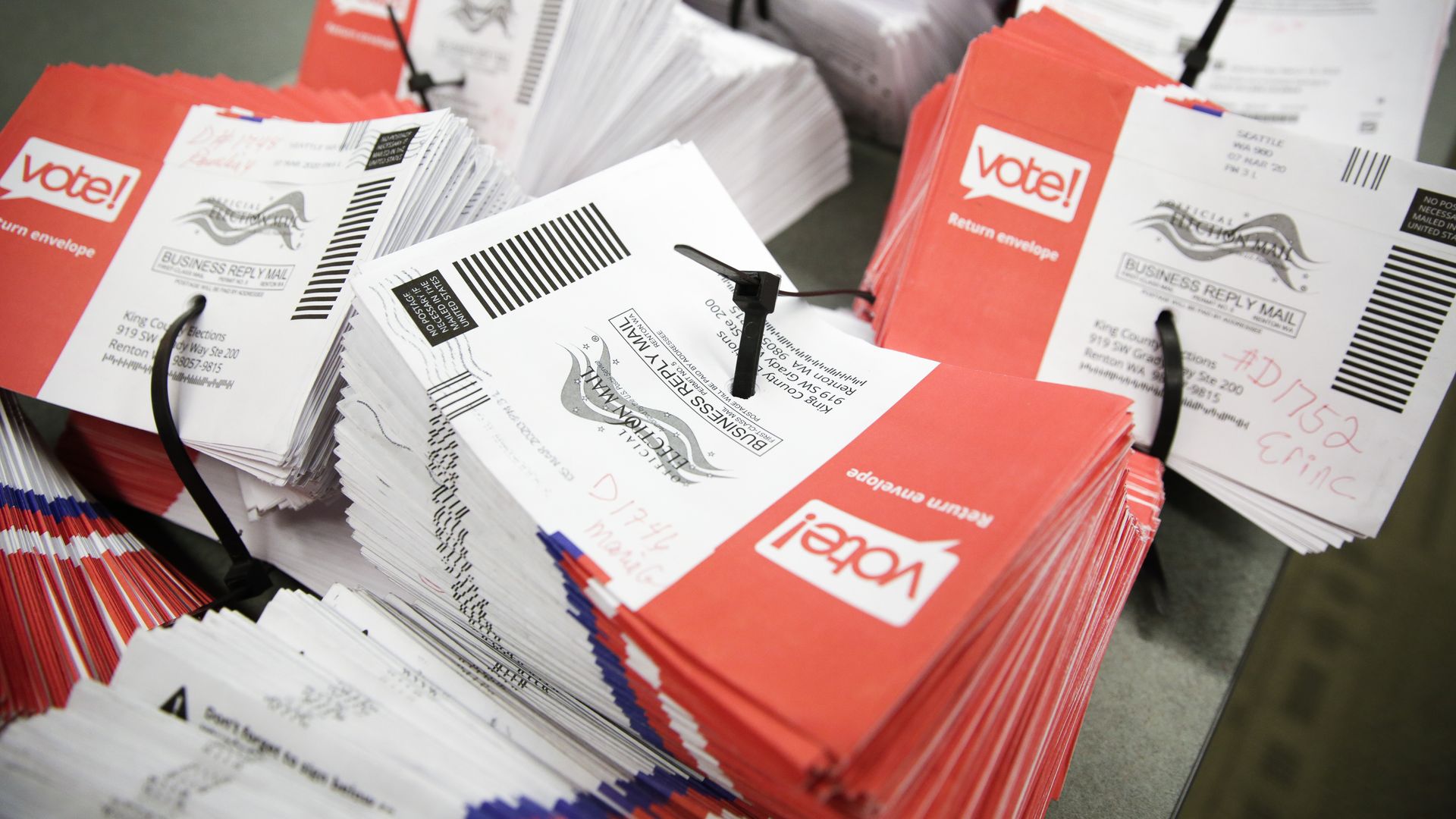 Stacks of empty envelopes from mail-in-ballots are stacked on a table.