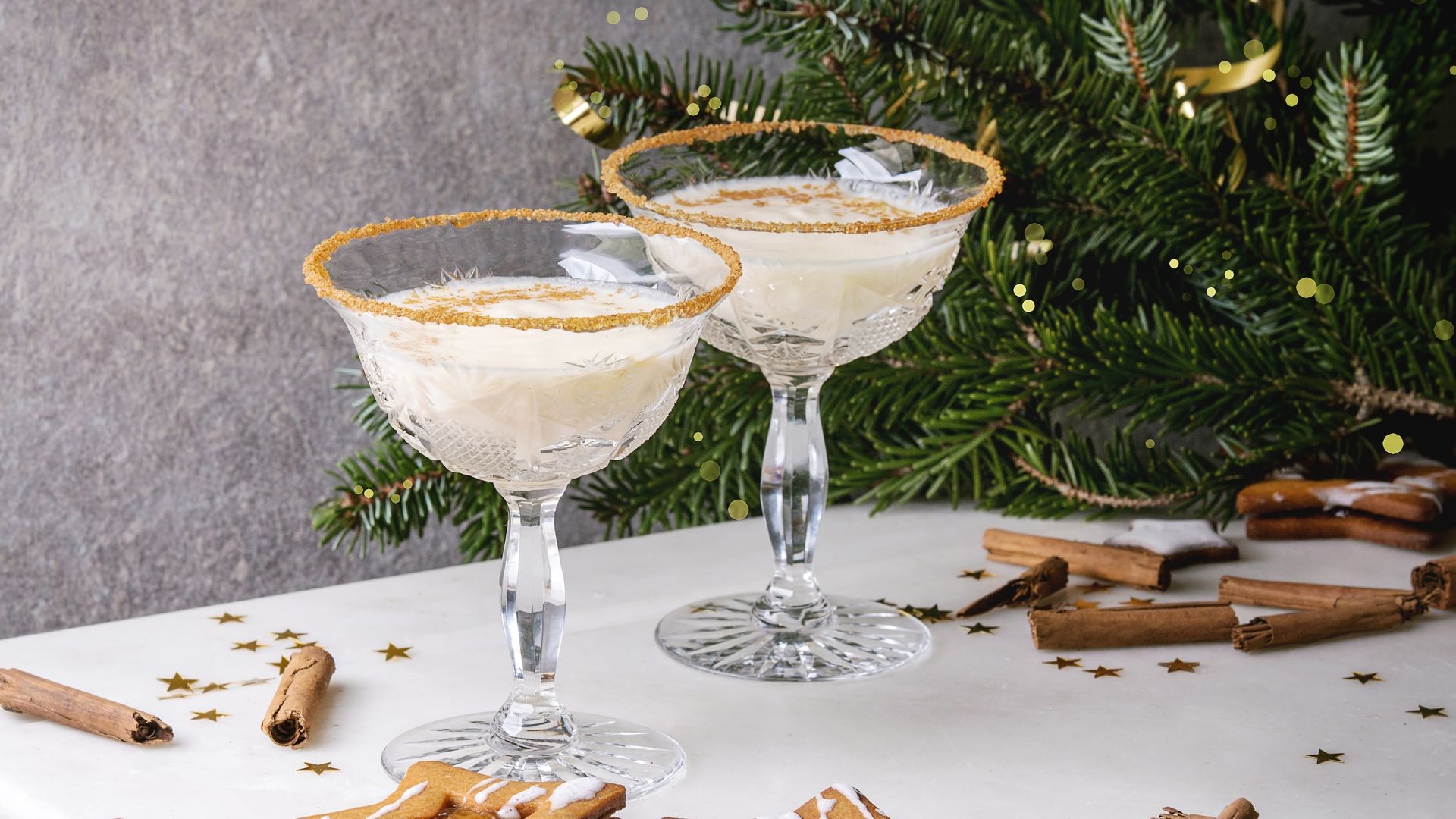 Two glass cups with cinnamon around the rim, filled with egg nog.