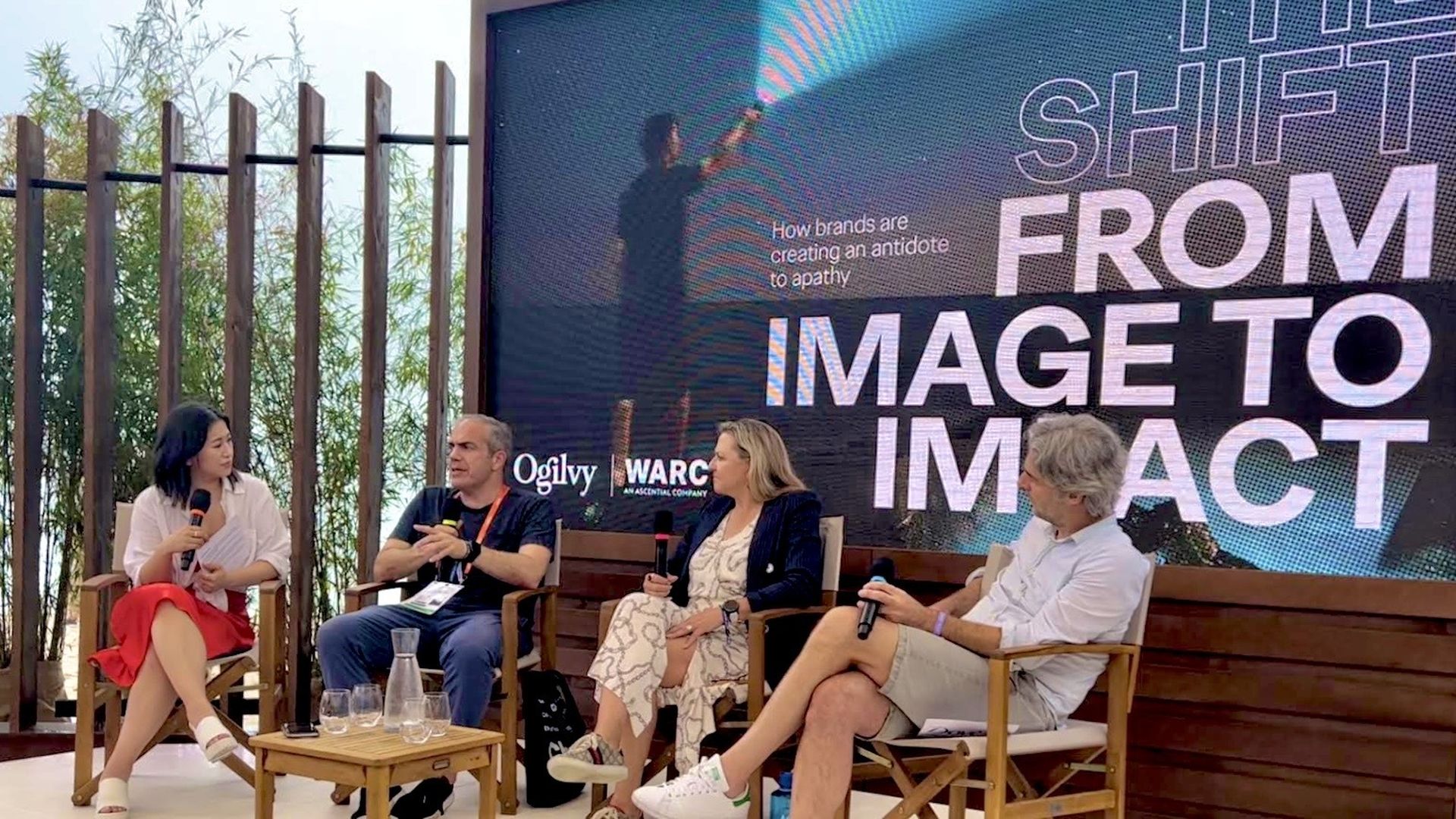 woman on a stage listening to a male panelist