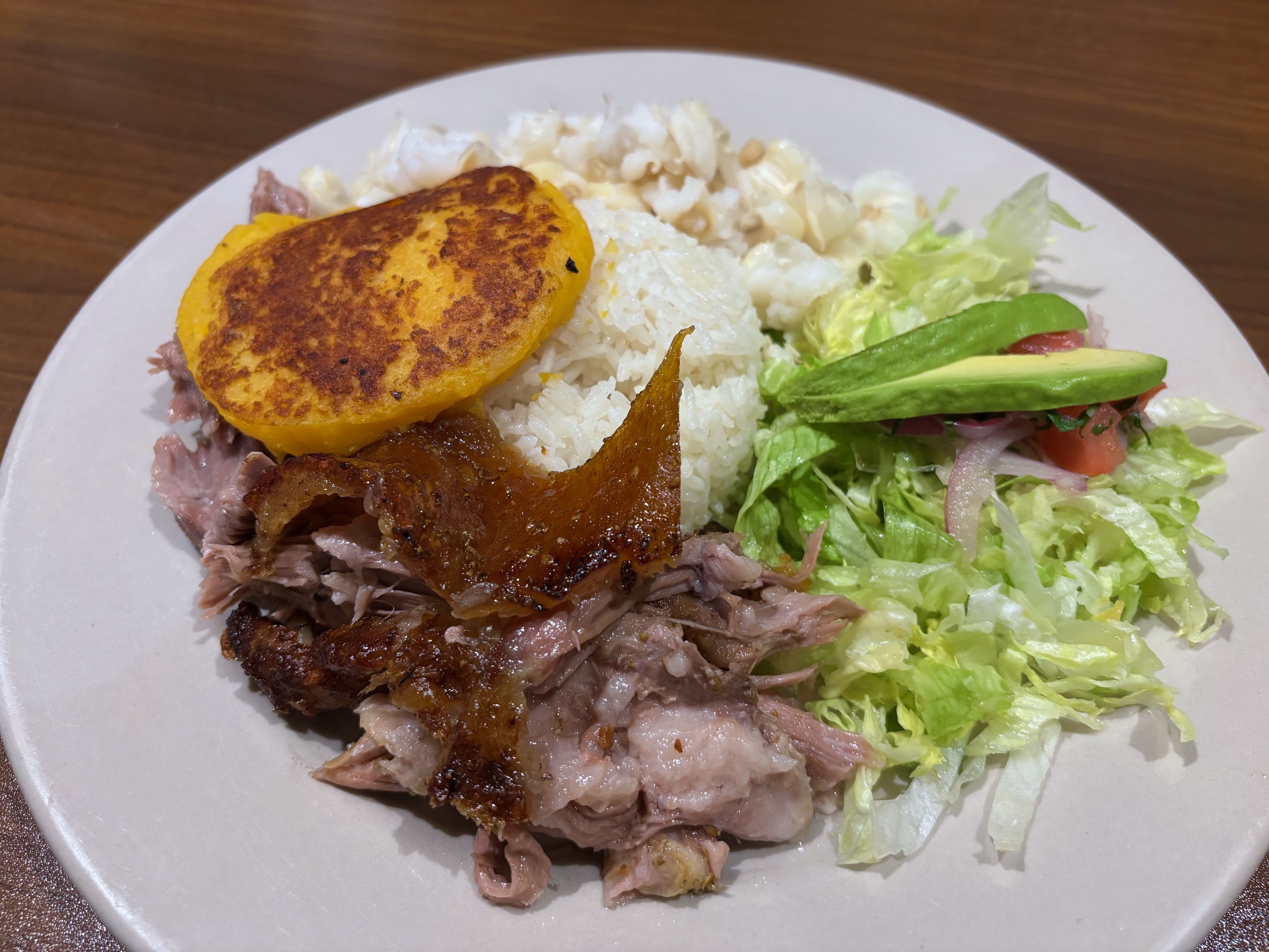 A close up of the hornado, topped with a fried plantain