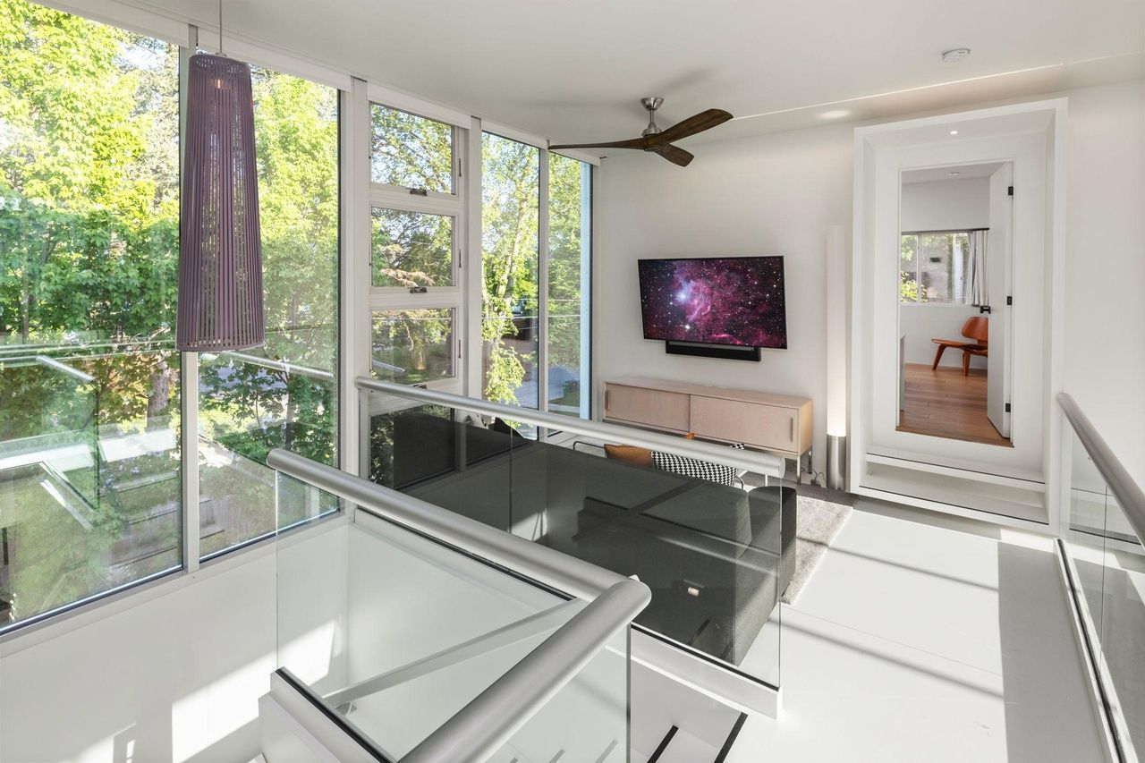 A room with glass walls looking out over a forest.