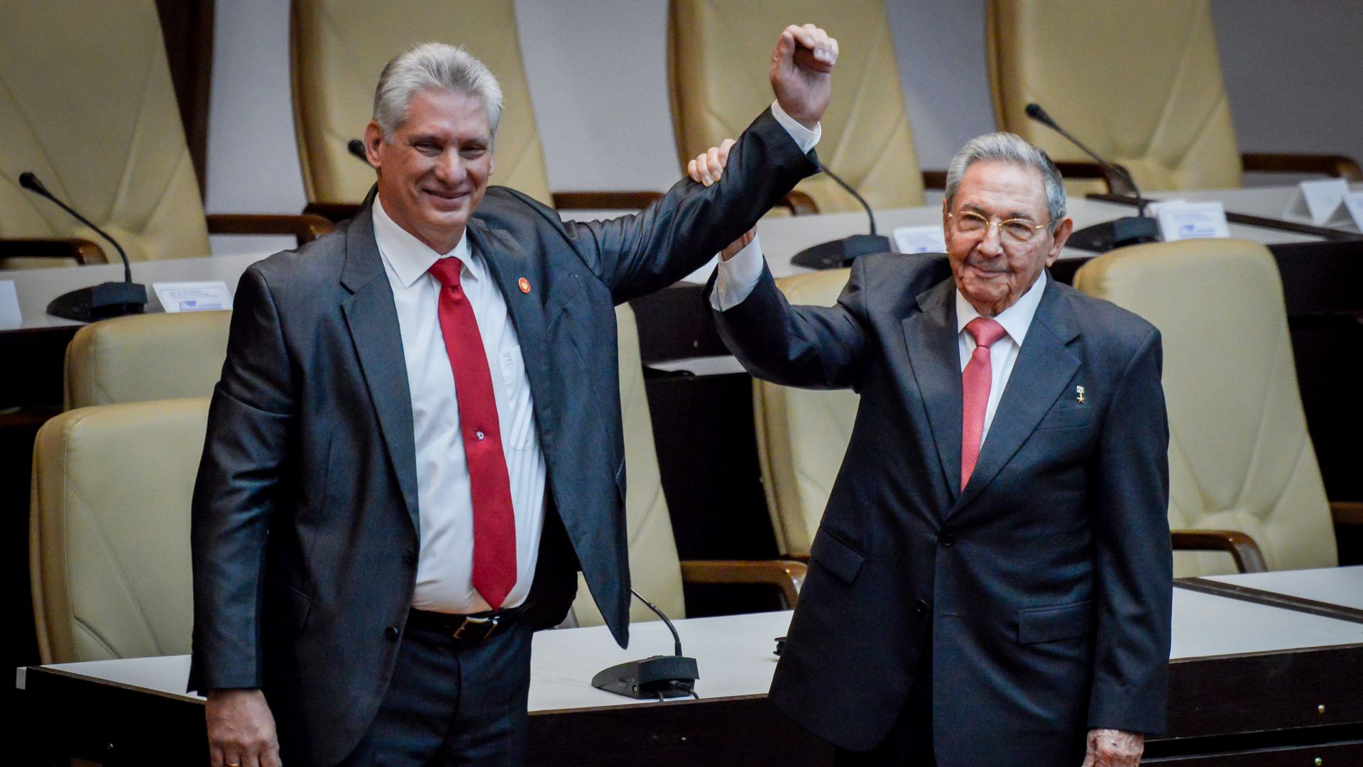 Former Cuban President Raul Castro raises the arm of newly elected Cuban President Miguel Diaz-Canel.