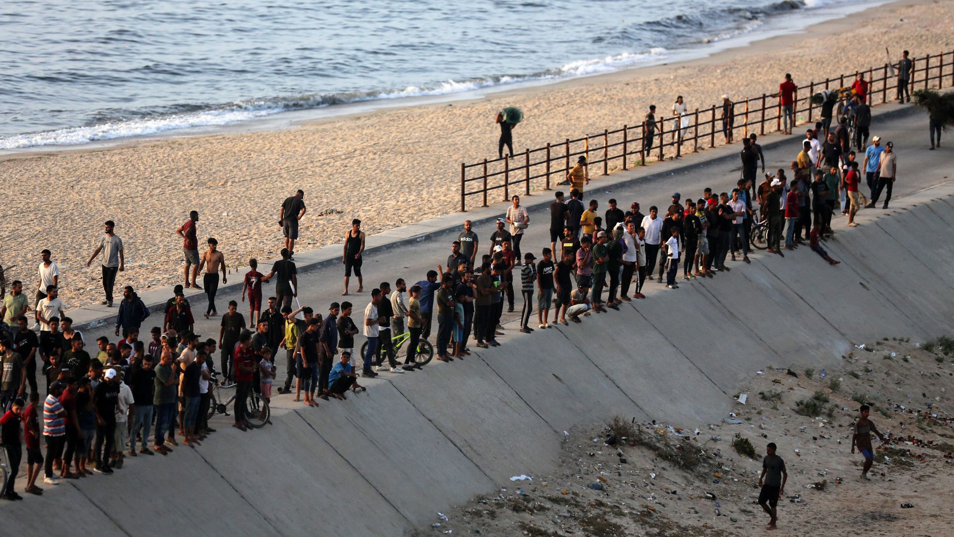 Palestinians gather near the water in the hope of obtaining aid delivered into Gaza through a U.S.-built pier.
