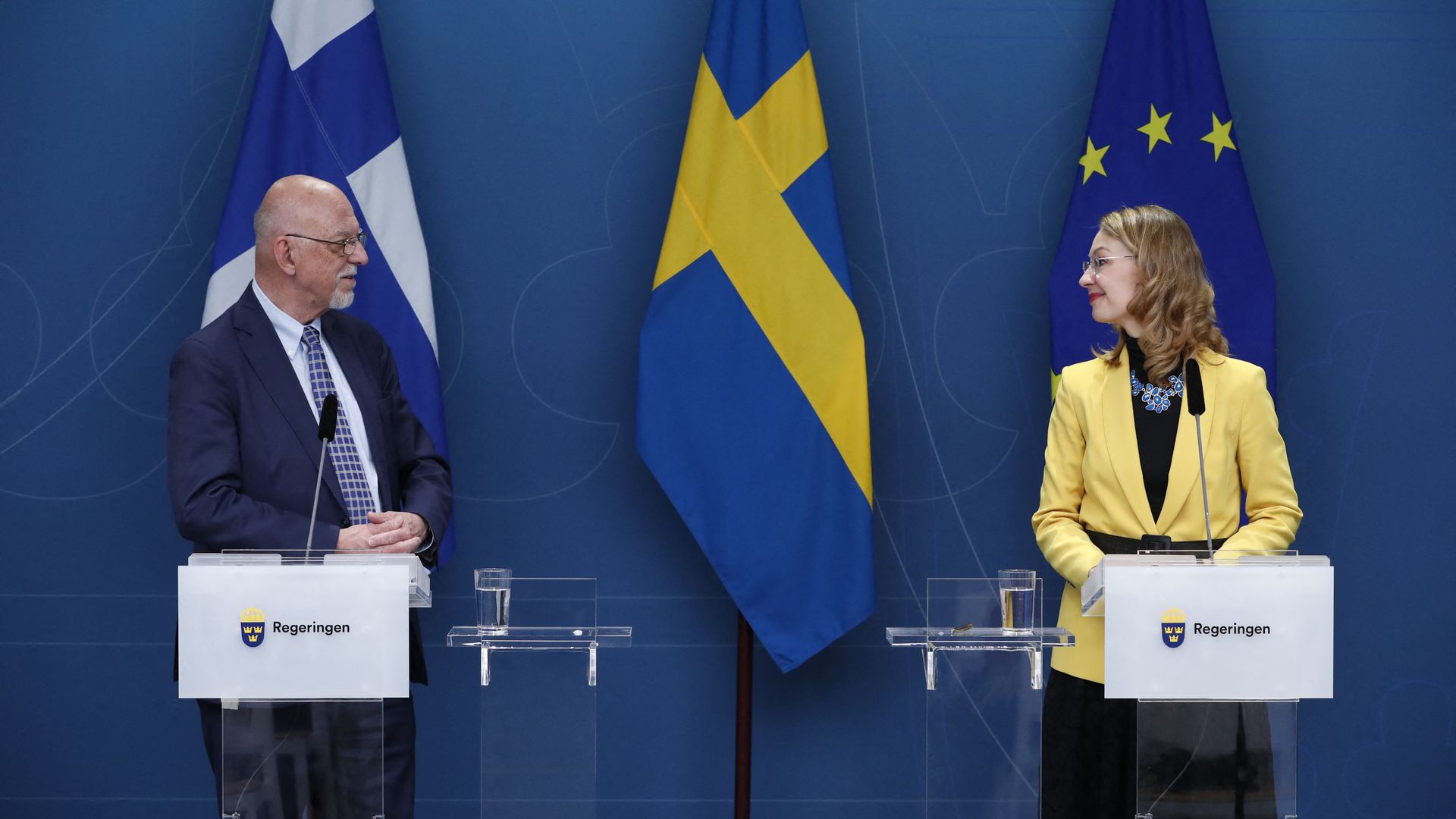 Photo of Hans Dahlgren (eft) and Tytti Tuppurainen (right) standing at two podiums and speaking to each other