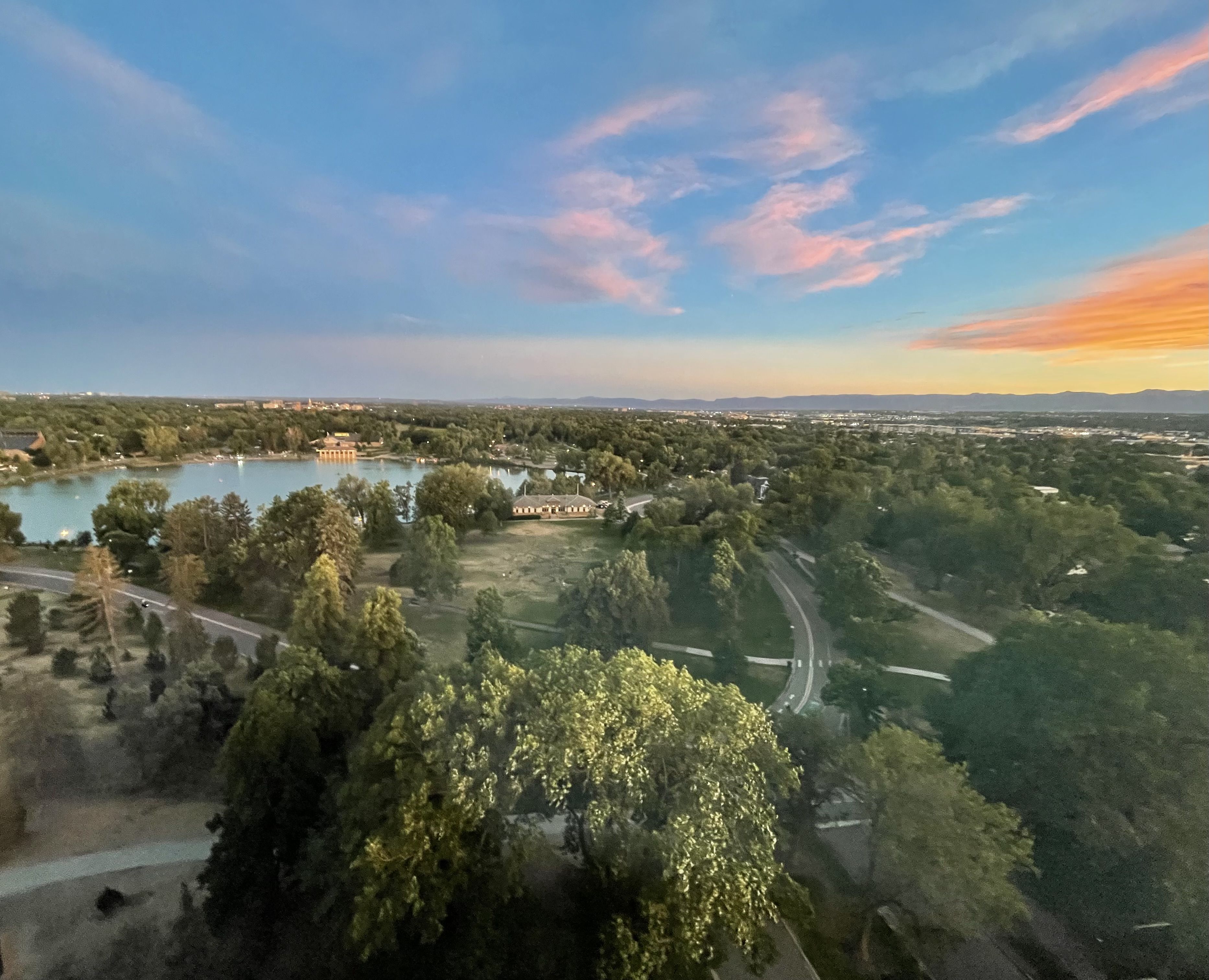 Above photo of a green lush park with water and colorful skies in Denver, CO