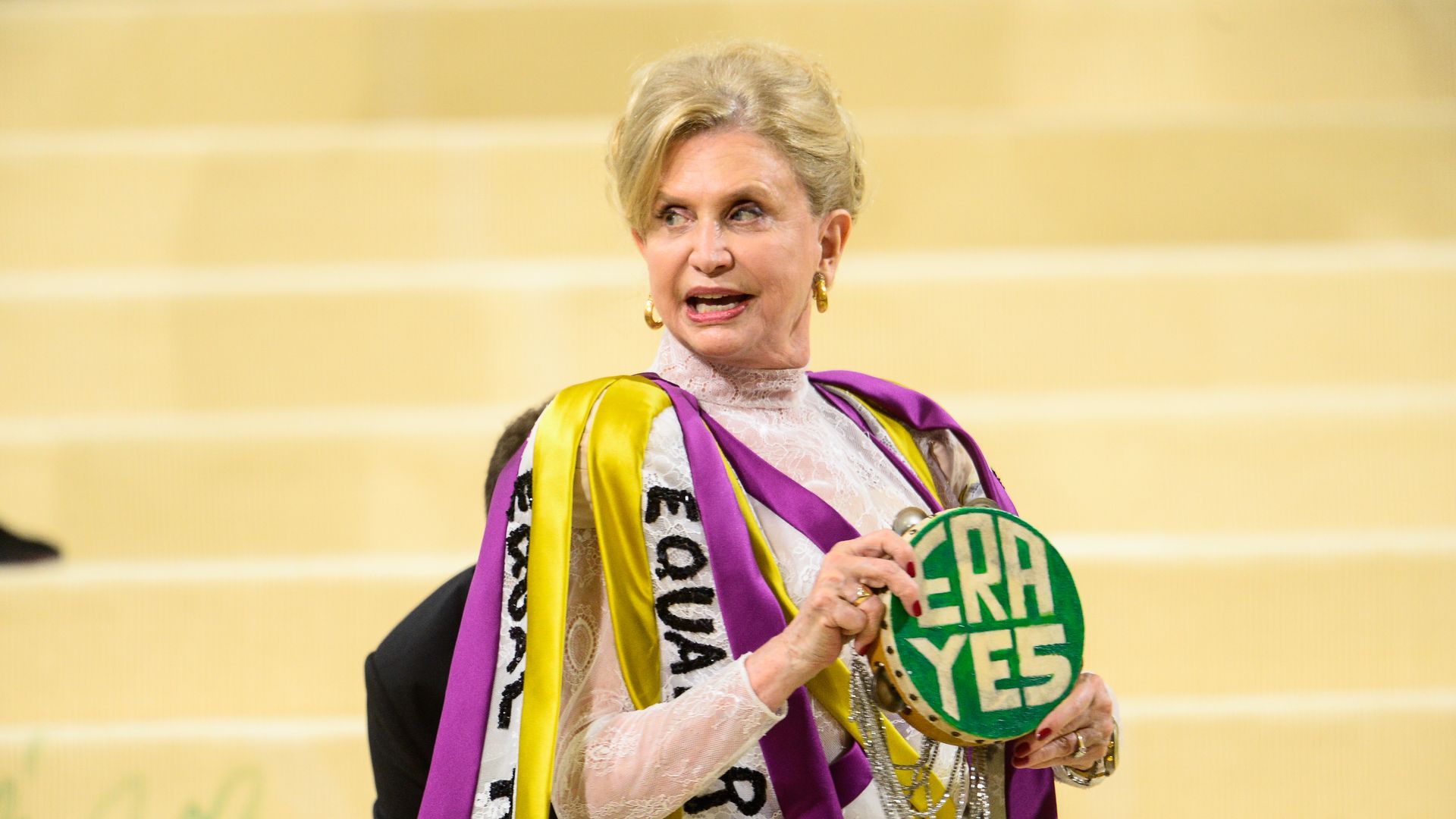 Rep. Carolyn Maloney at the Met Gala in a yellow, green, purple and white outfit touting the Equal Rights Amendment.