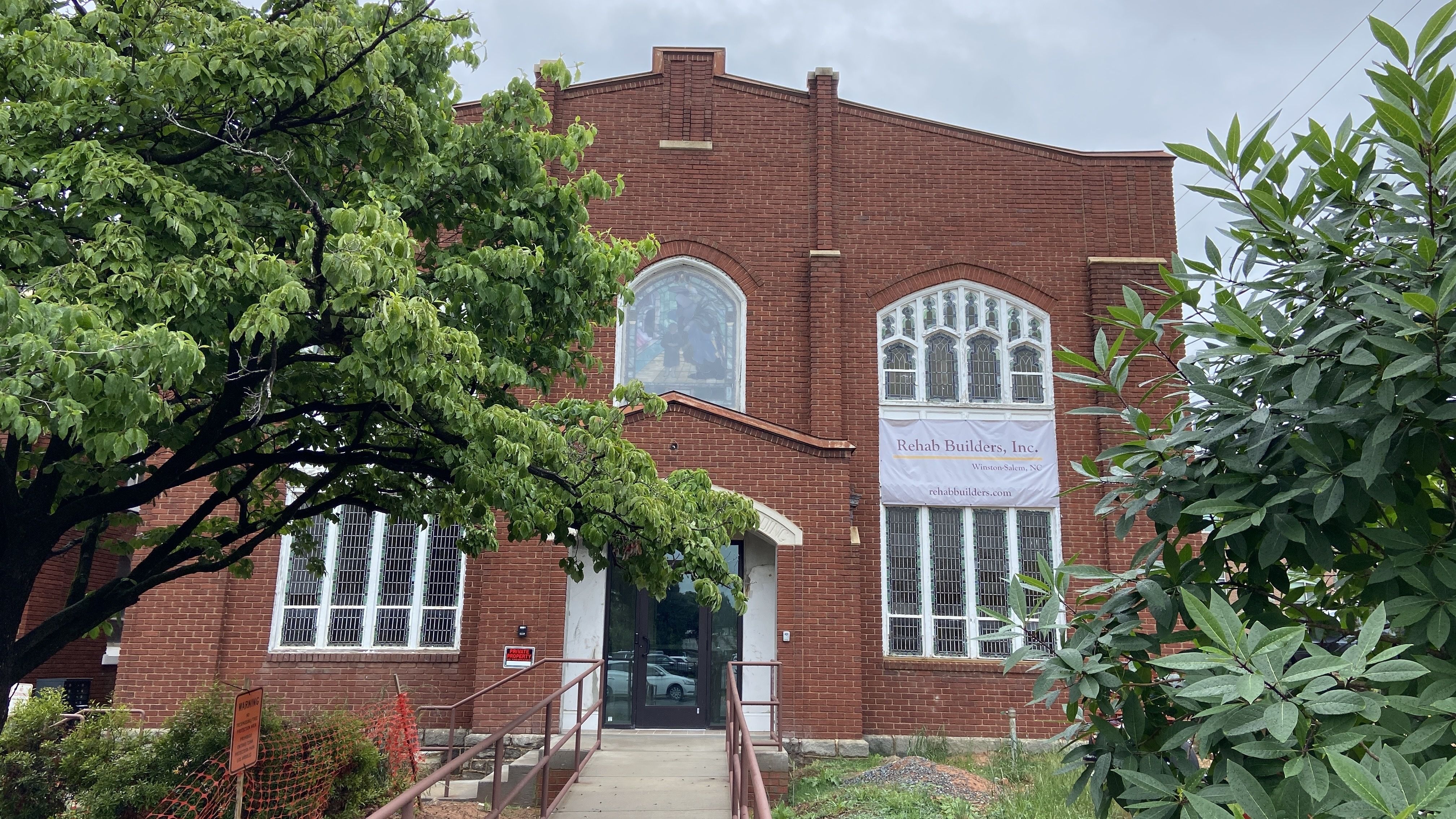 Brick exterior of Easter's Home, surrounded by trees, in Elizabeth. A stained glass window faces 5th Street.